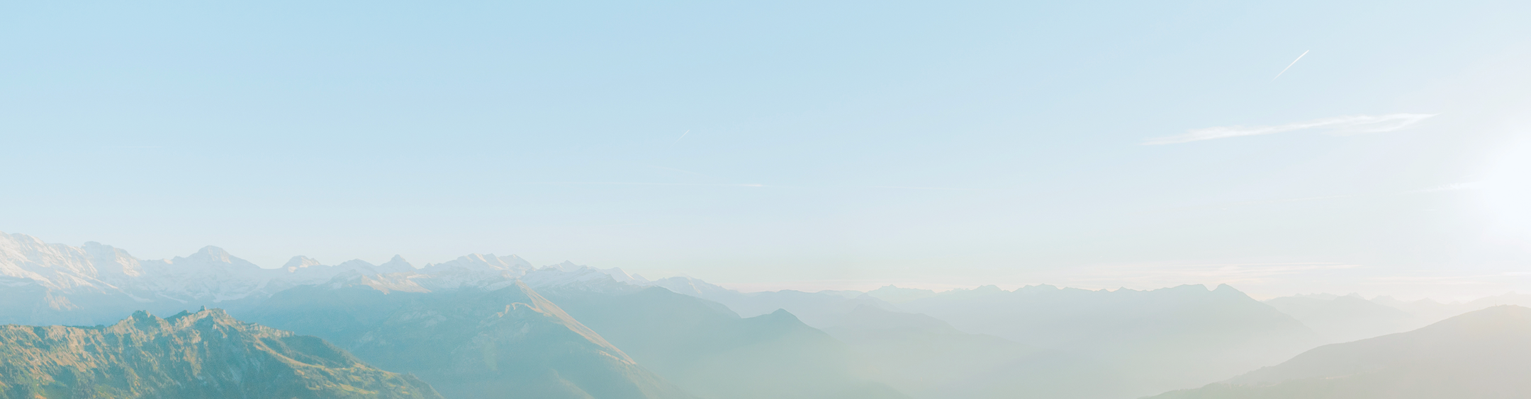 Ciel bleu clair au-dessus d’une chaîne de montagnes escarpées et enneigées par une journée ensoleillée.