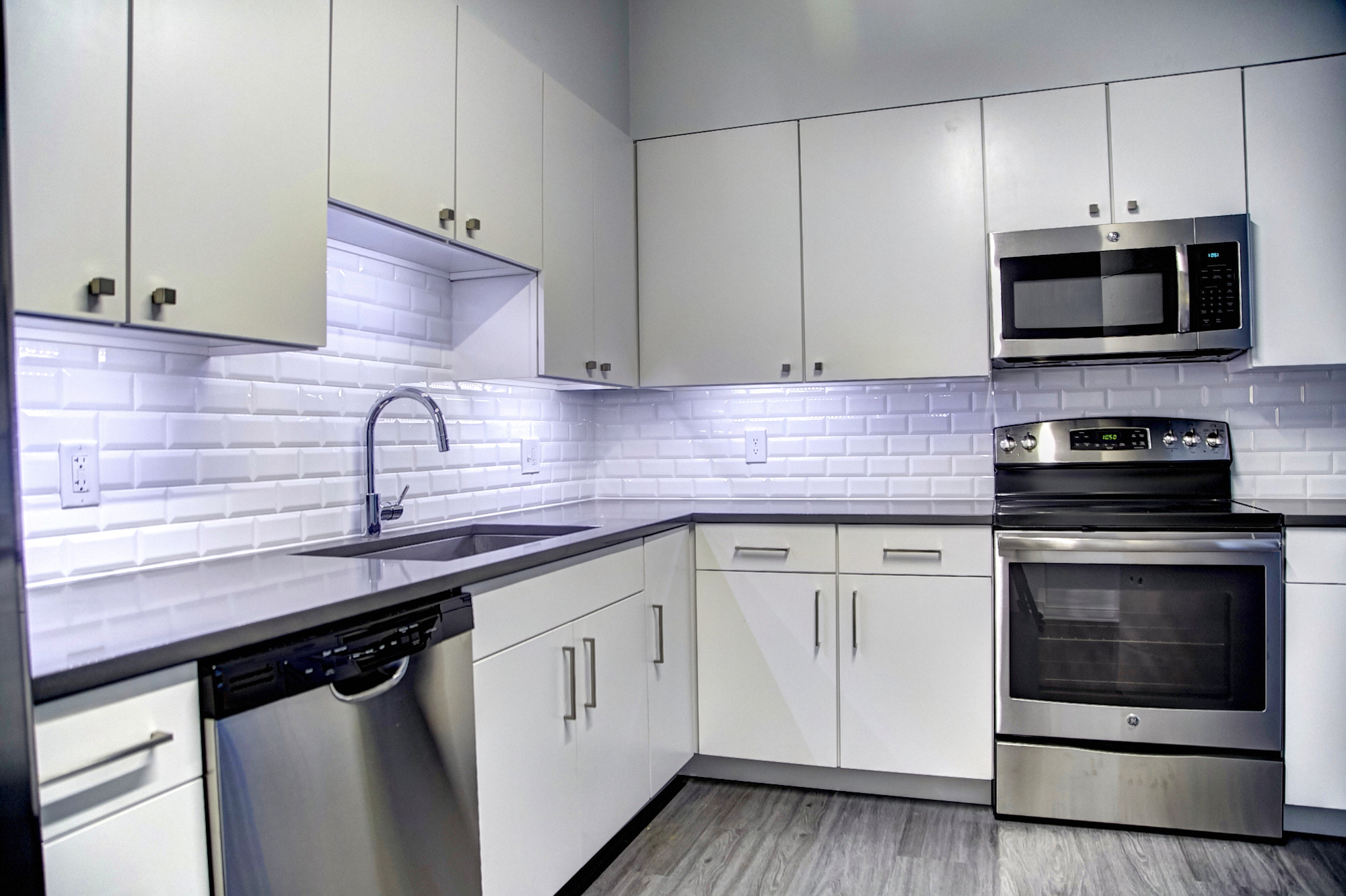 A kitchen with a dishwasher an oven and a granite countertop 