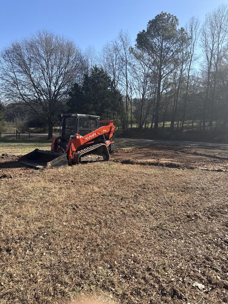 Photo of compact equipment working across a cleared field for forestry mulching, brush removal, or land clearing services.
