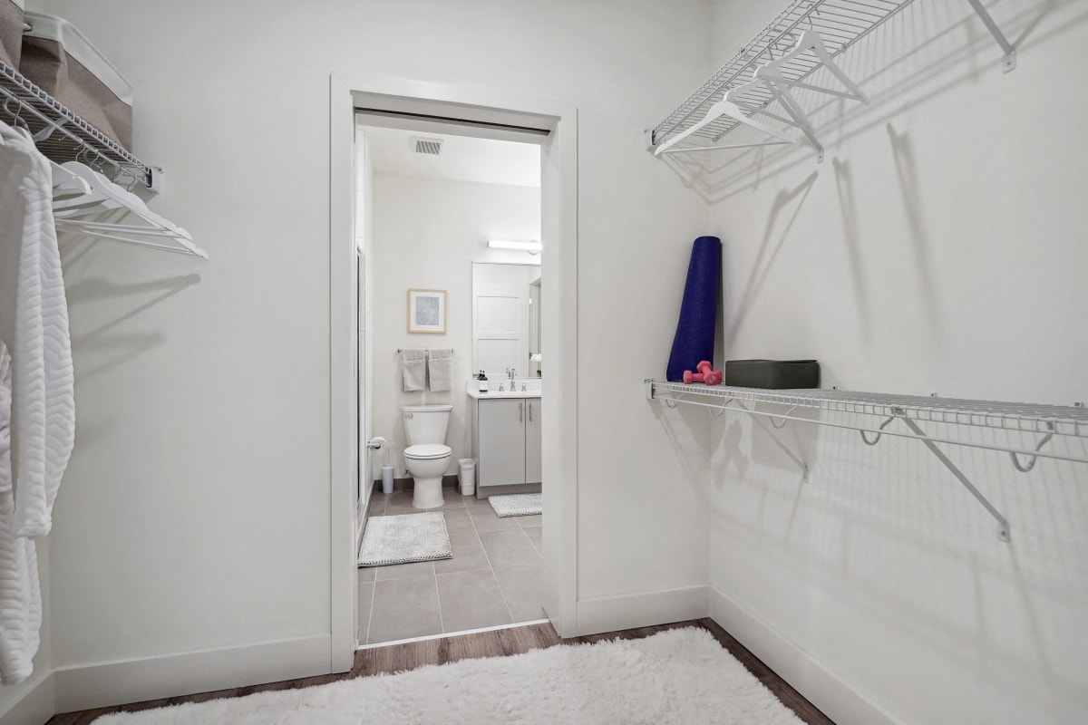 a white bathroom with a white rug and a closet