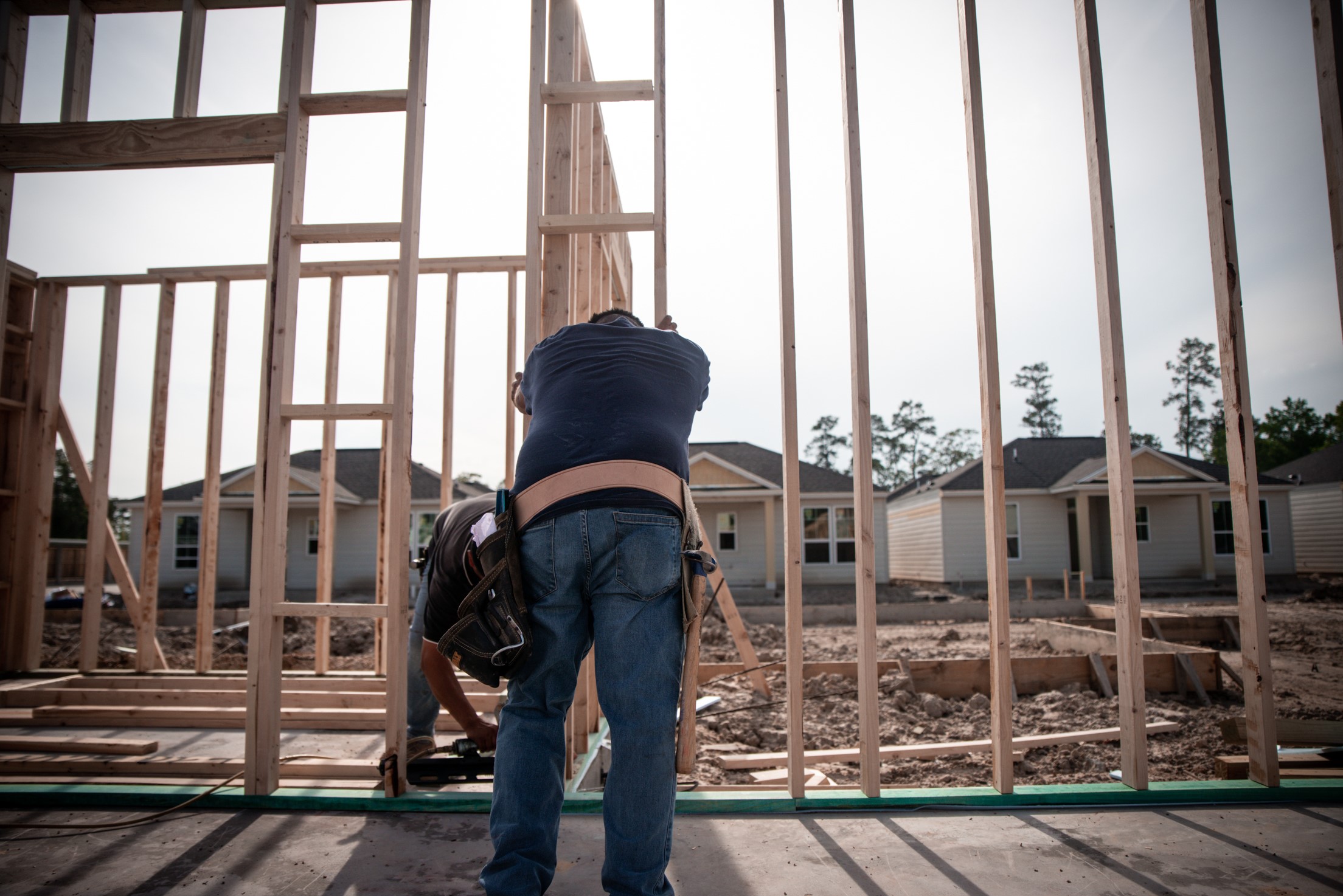 Building materials supplier Builders FirstSource's forklift is moving wood roof trusses.