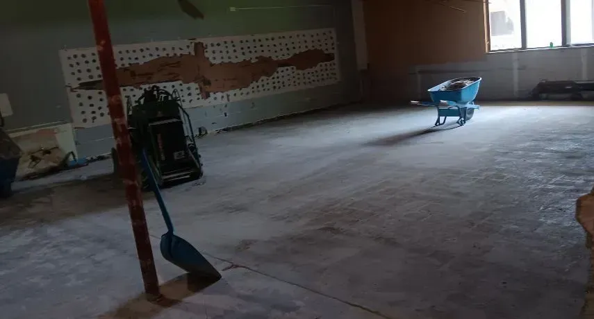 Large interior concrete floor prepared for restoration, polishing, or coating with professional equi 