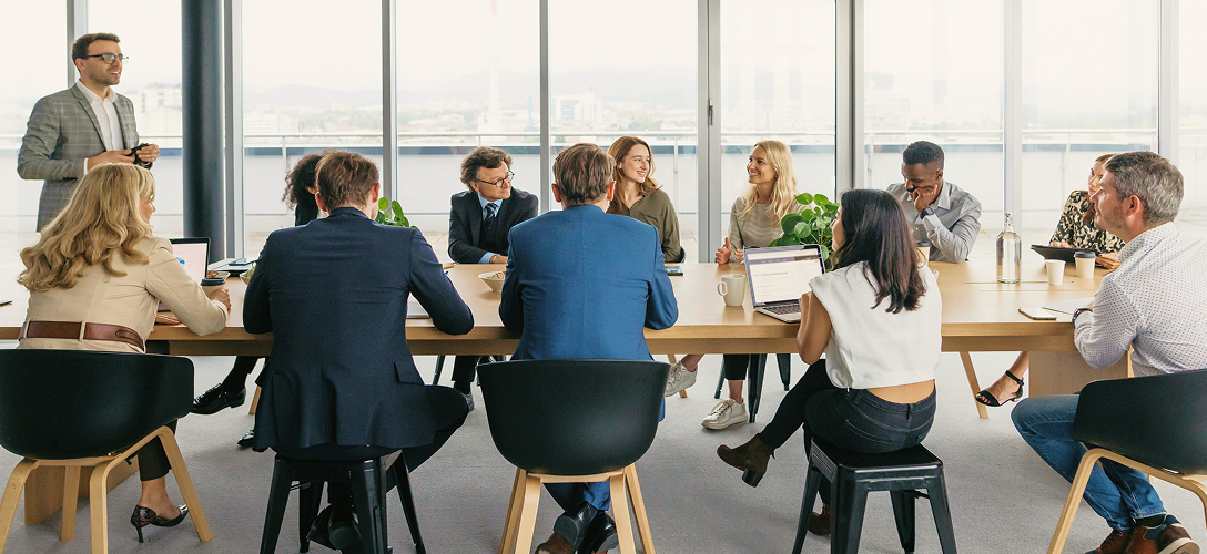 A large group of people seated in a boardroom.