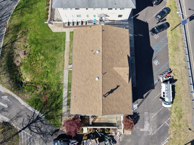 Aerial view showcasing a completed roofing project with newly installed shingles. Professional craft 
