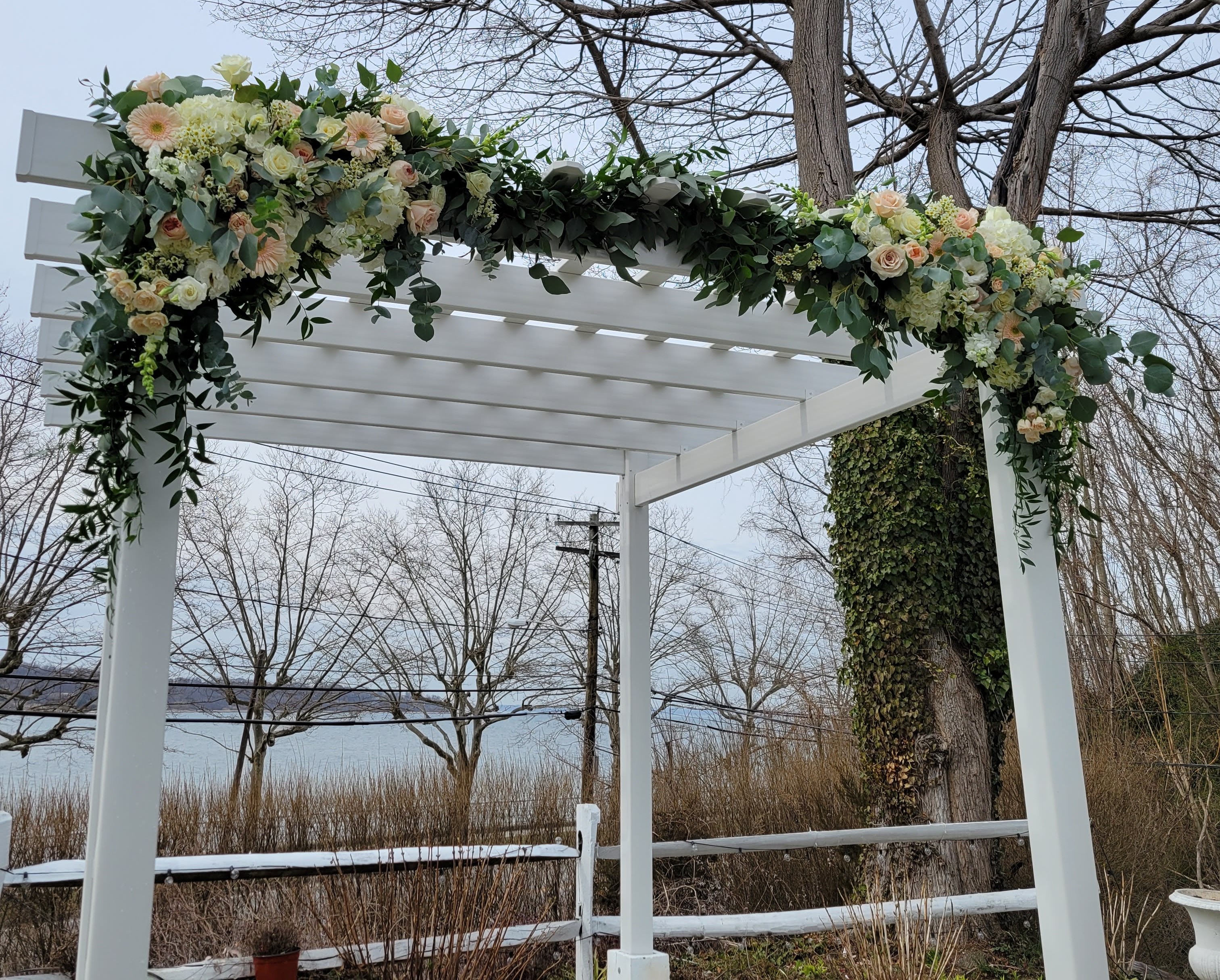 March wedding ceremony arch with spring flowers in a neutral color palette at Seacliff Manor, Seacliff NY
