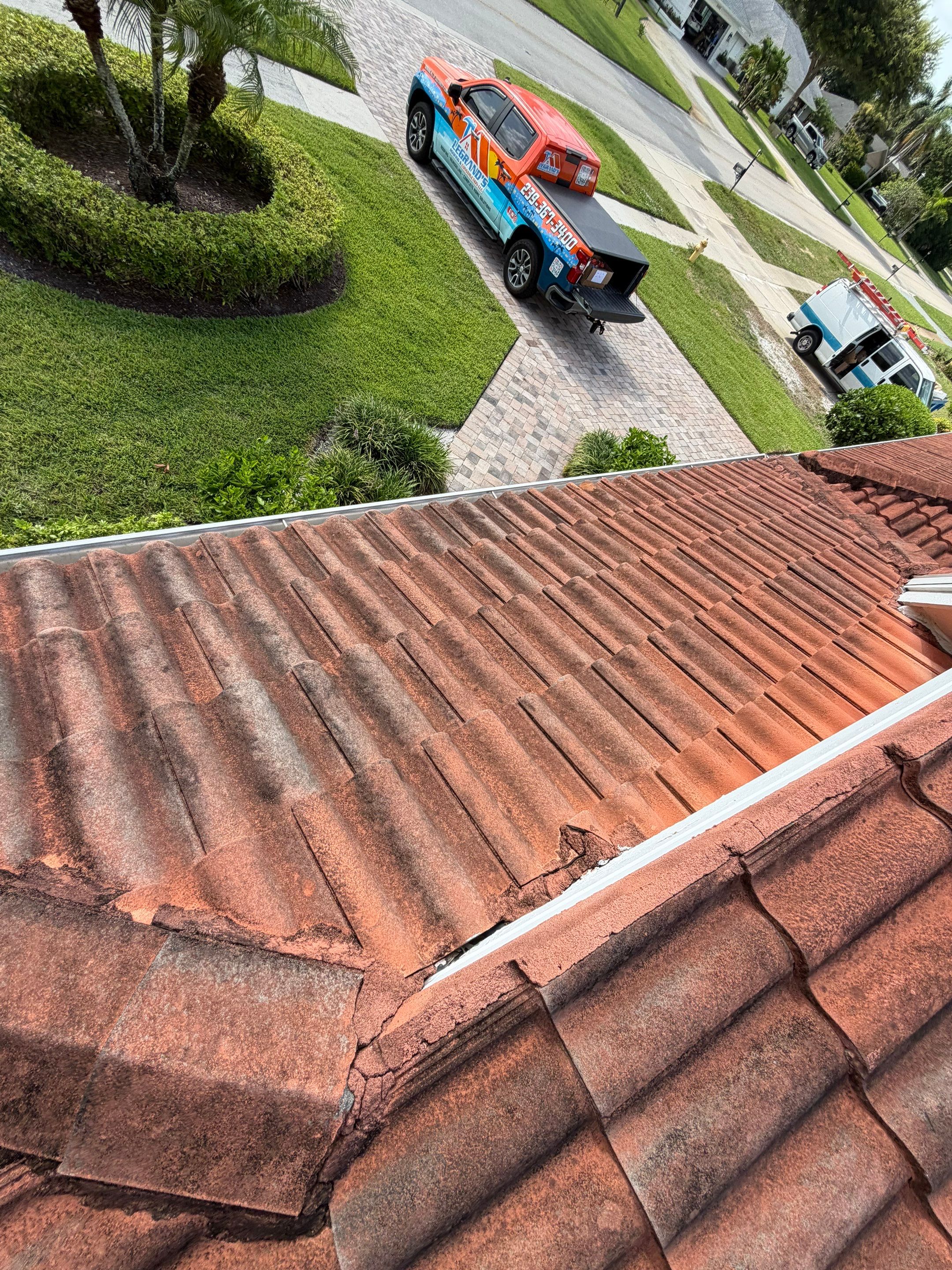 Close-up view of a tile roof showing roofing components and repair work near the roof edge. 