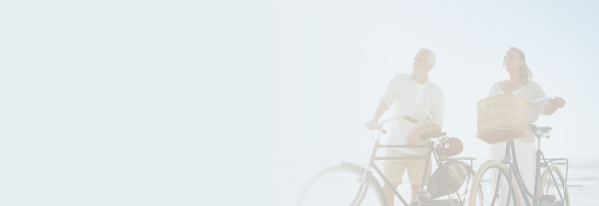 A couple riding their bikes together in the sun.