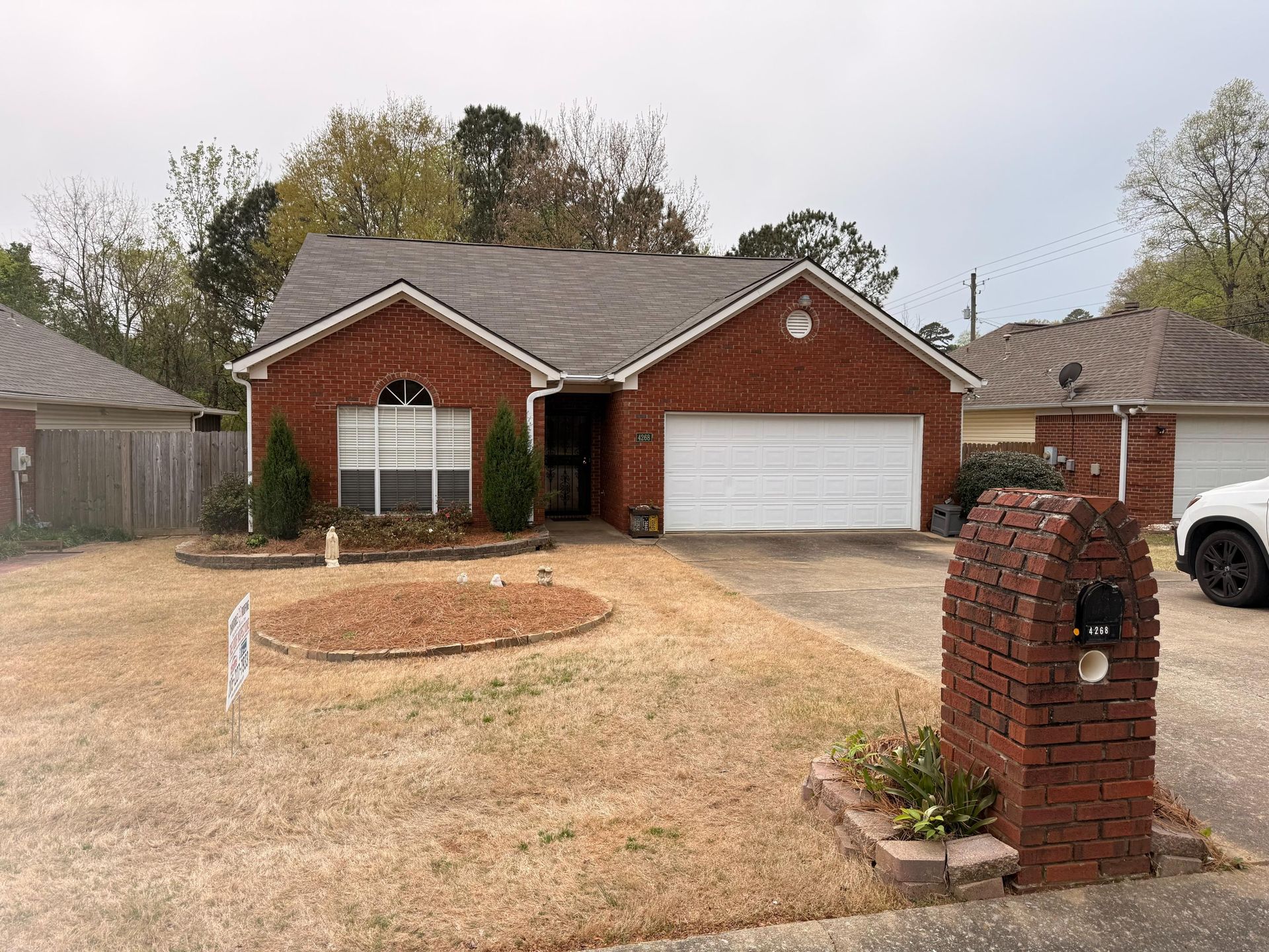 Single-story brick residence featuring a professionally installed gray asphalt shingle roof that enh 