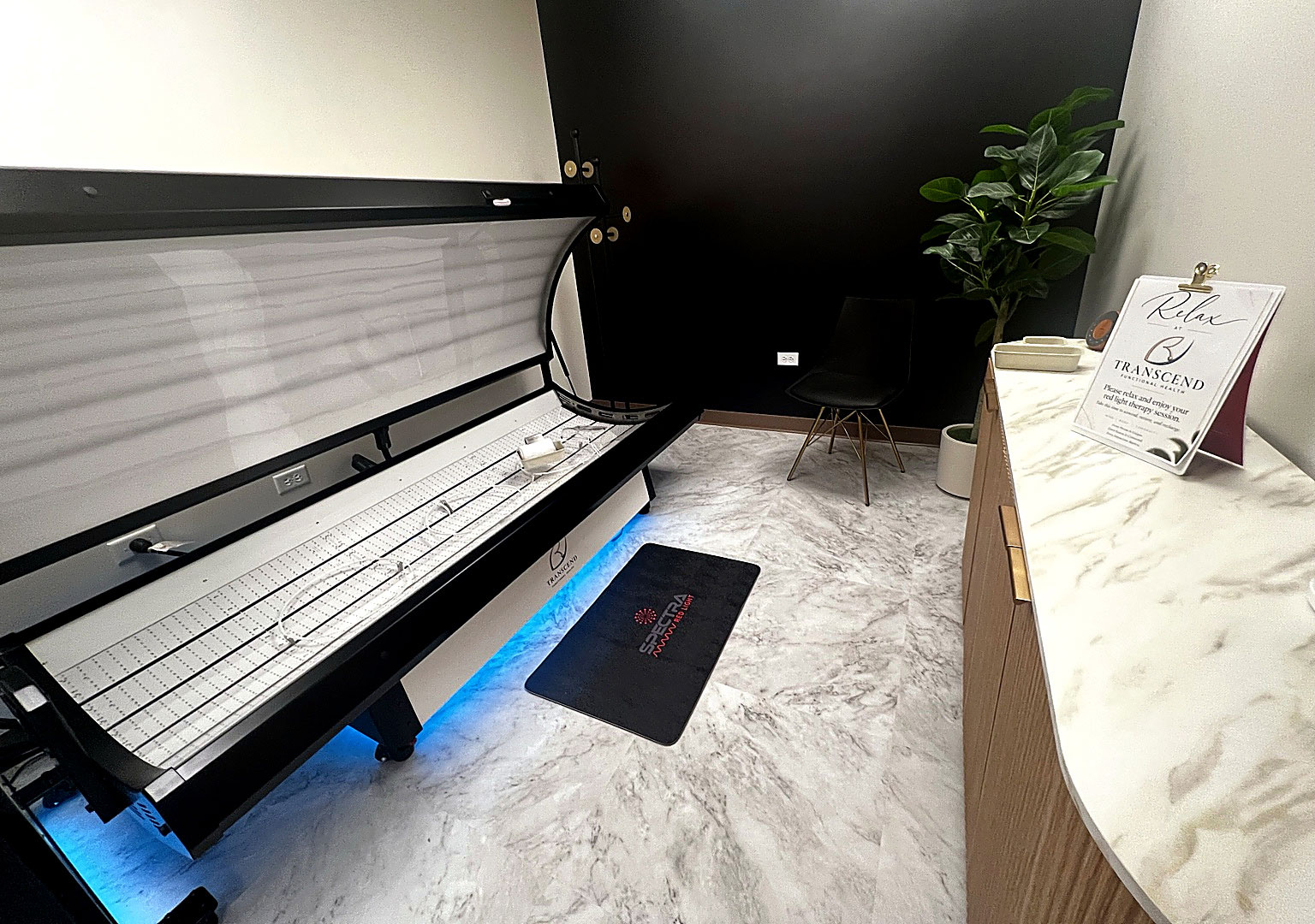 Full-body red light therapy treatment area at Transcend Functional Health in Greenwood Village, with a modern therapy bed in a private, calming clinical environment.