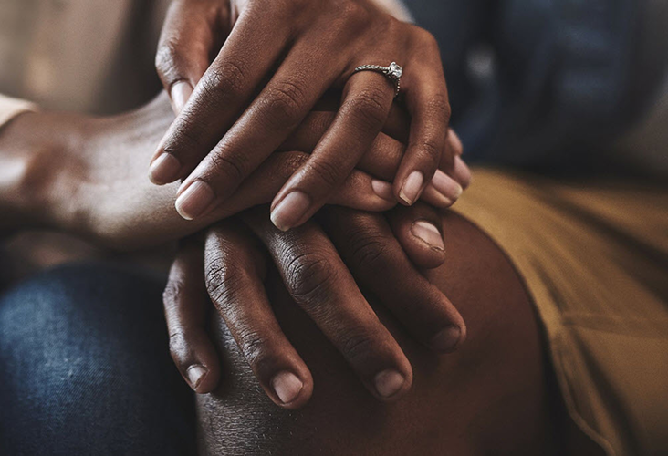 Closeup of a married couple holding hands.
