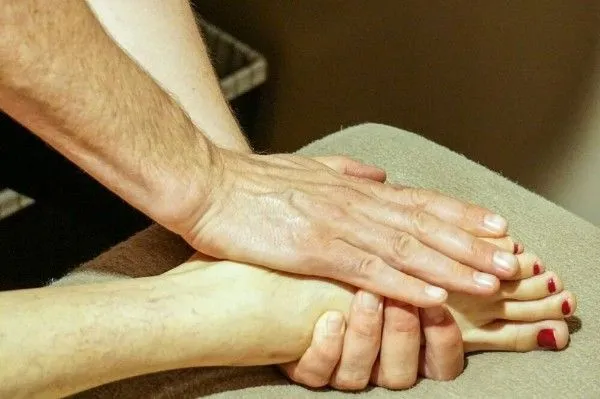 Therapist performing focused foot therapy using skilled hand techniques to relieve tension, improve  