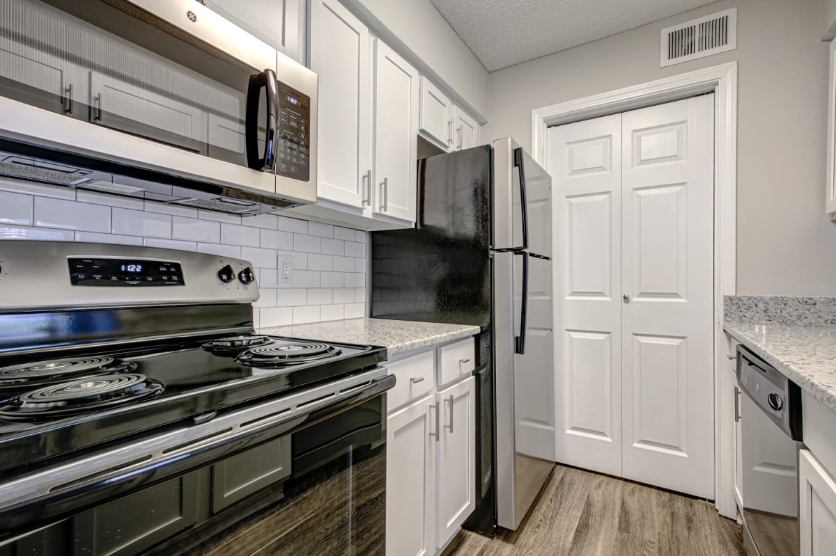 Upgraded Units Available with Sleek Black Appliances, Vinyl Plank Wood Flooring, Ceramic Tile Backsplash and Granite Like Countertops at The Edge of Germantown Apartments Home