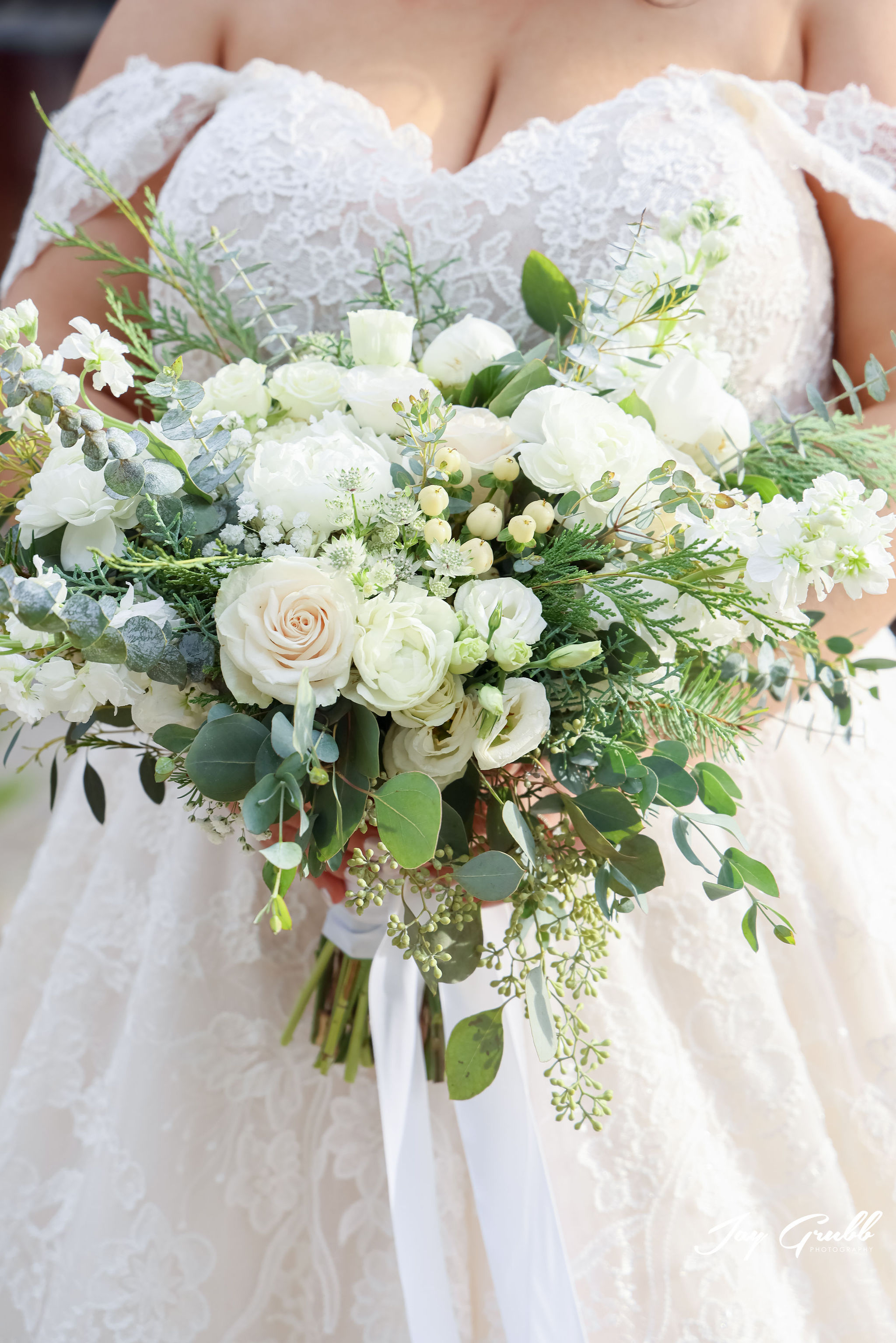 bride holding white rose bouquet 
