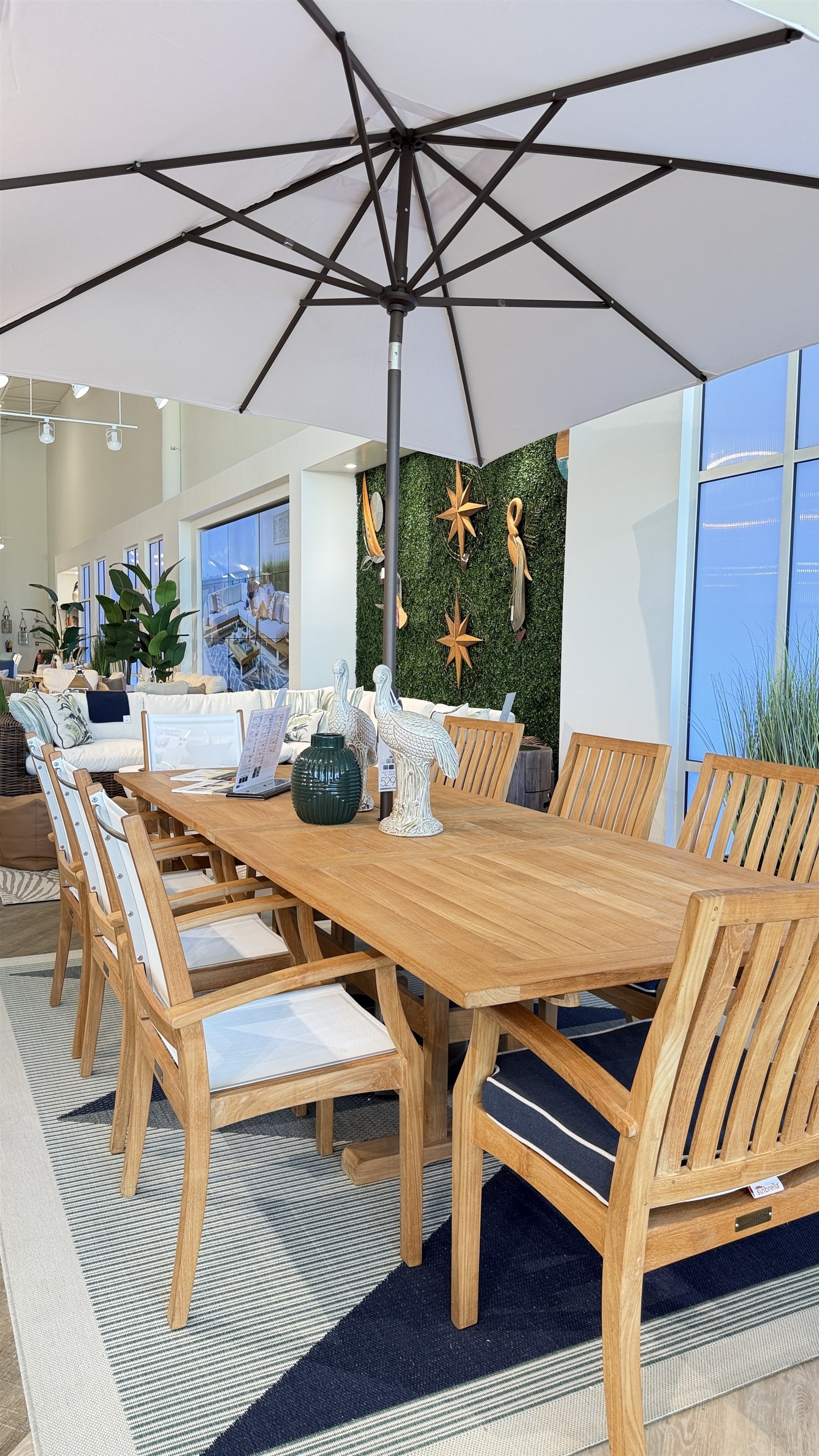 Gather around this teak outdoor dining set with a white market patio umbrella