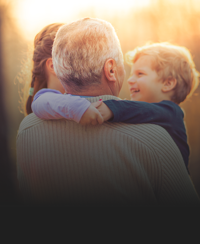 A grandfather holding his grandkids.