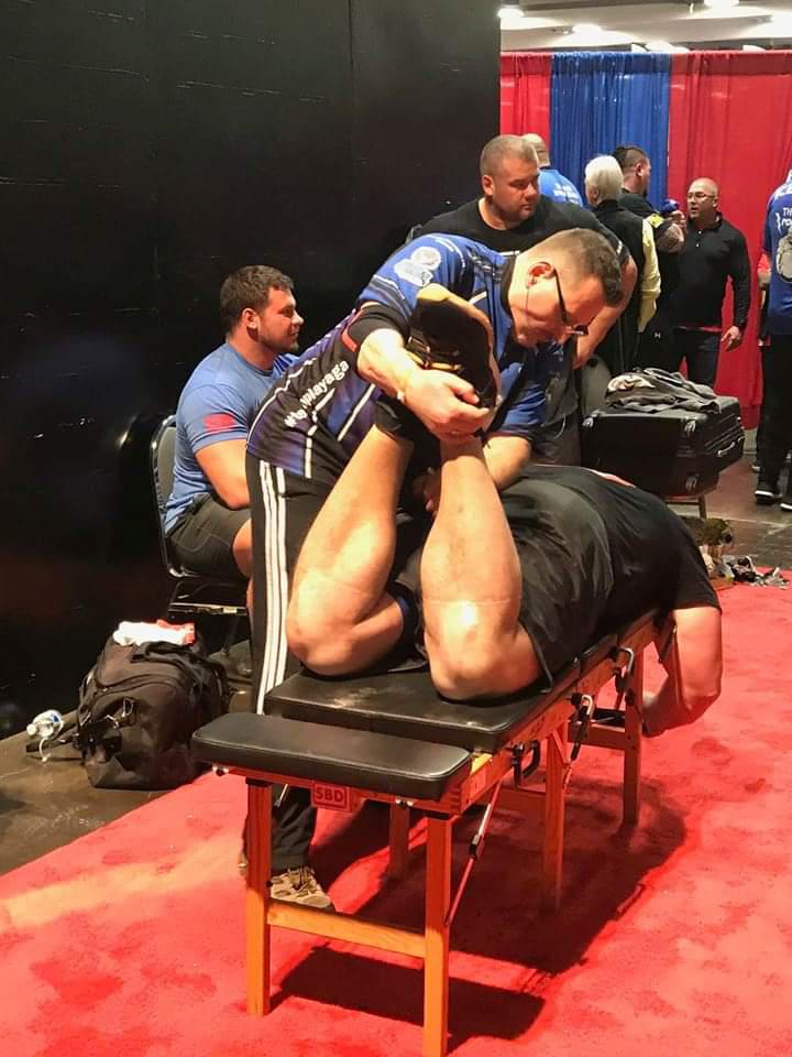 Dr. McDougle backstage at one of the competitions enhancing the performance of his strongman pals.