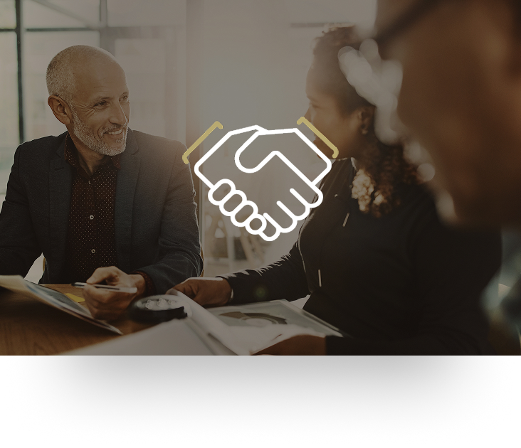 A professional meeting with two clients and going over paperwork.