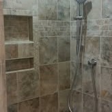 There is a new walk-in shower with tile, shampoo, and soap holders.