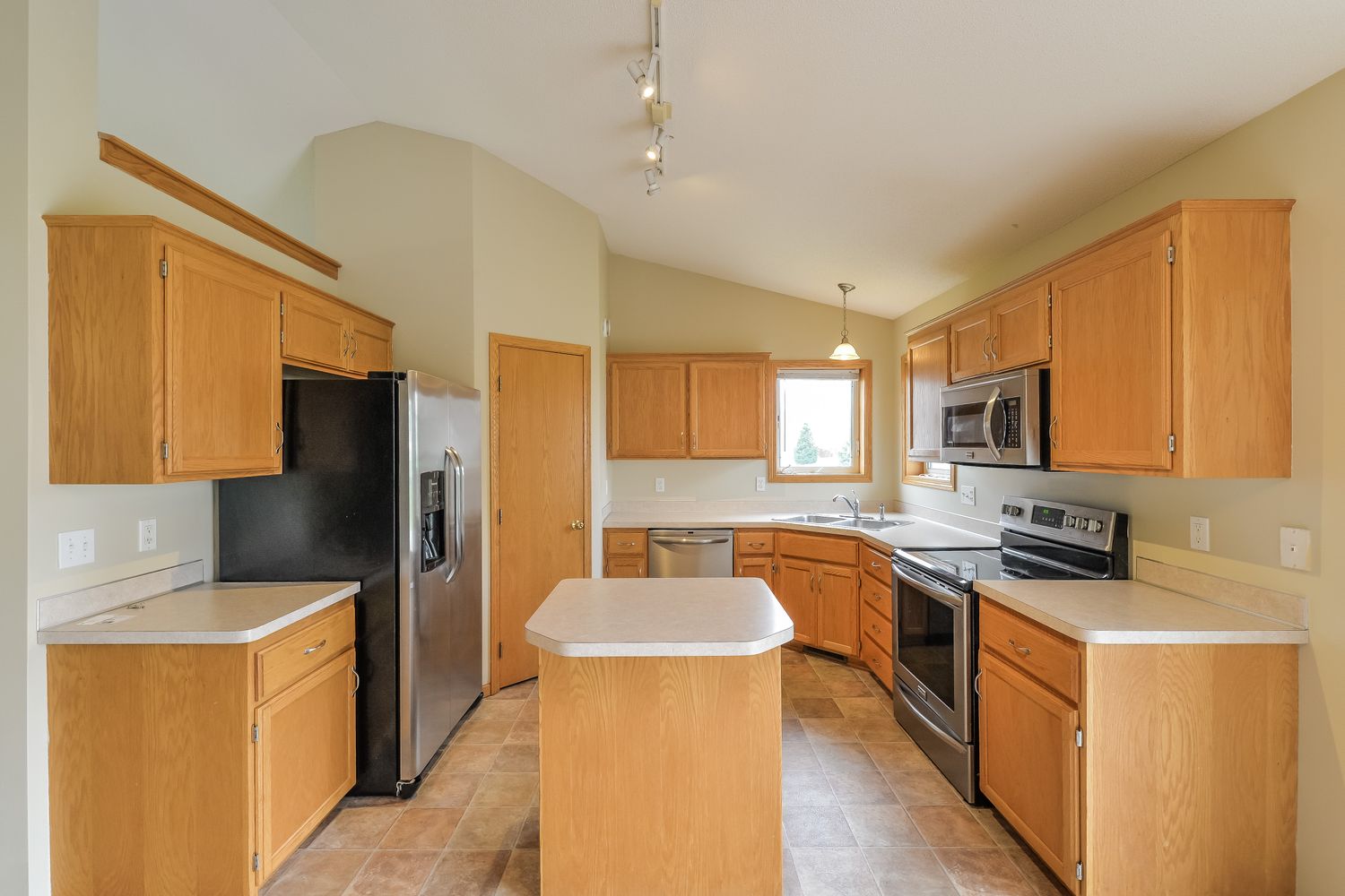 Spacious kitchen with island and stainless steel appliances at Invitation Homes Minneapolis.