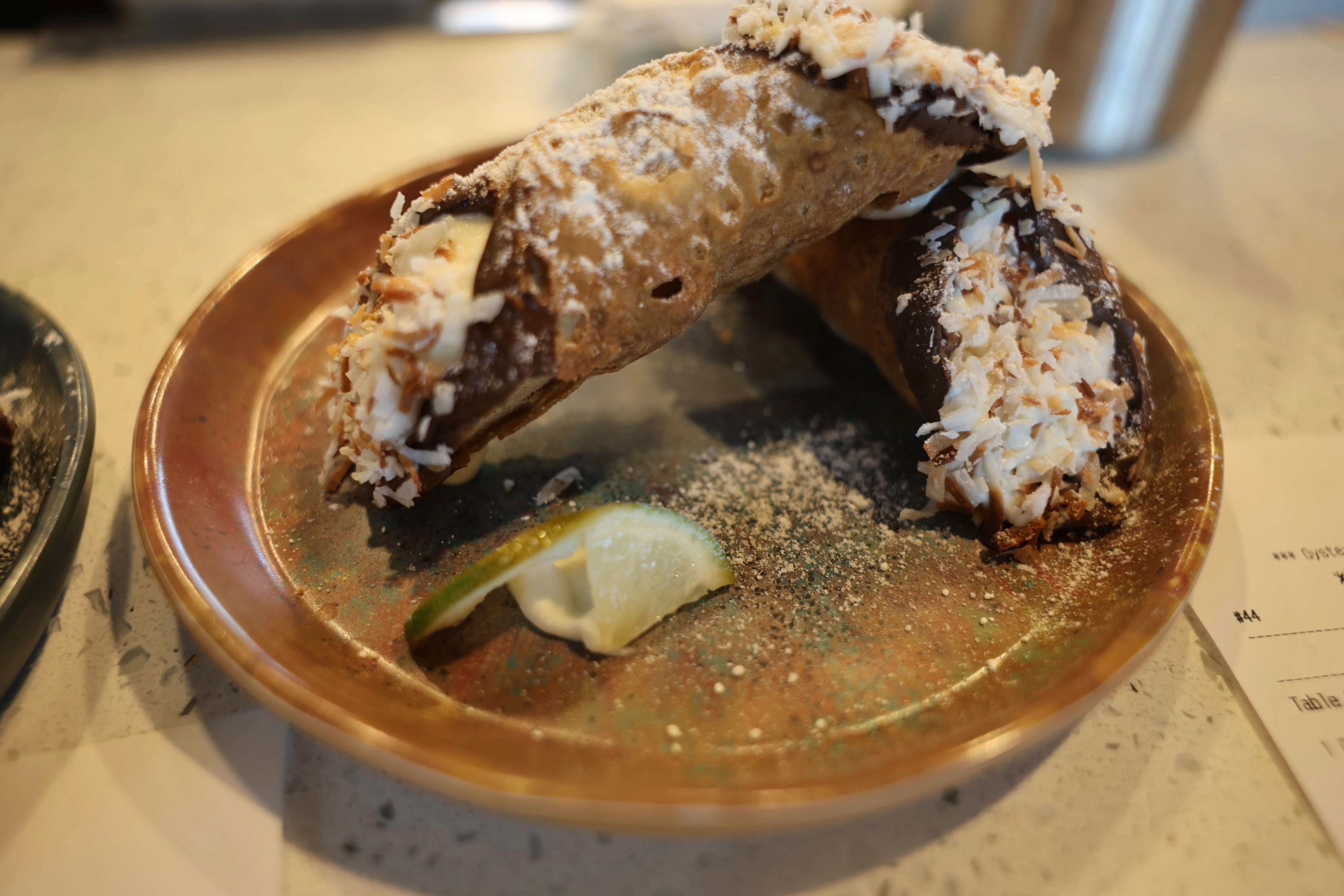 Chocolate-dipped cannoli shell, key lime cream, lime zest.