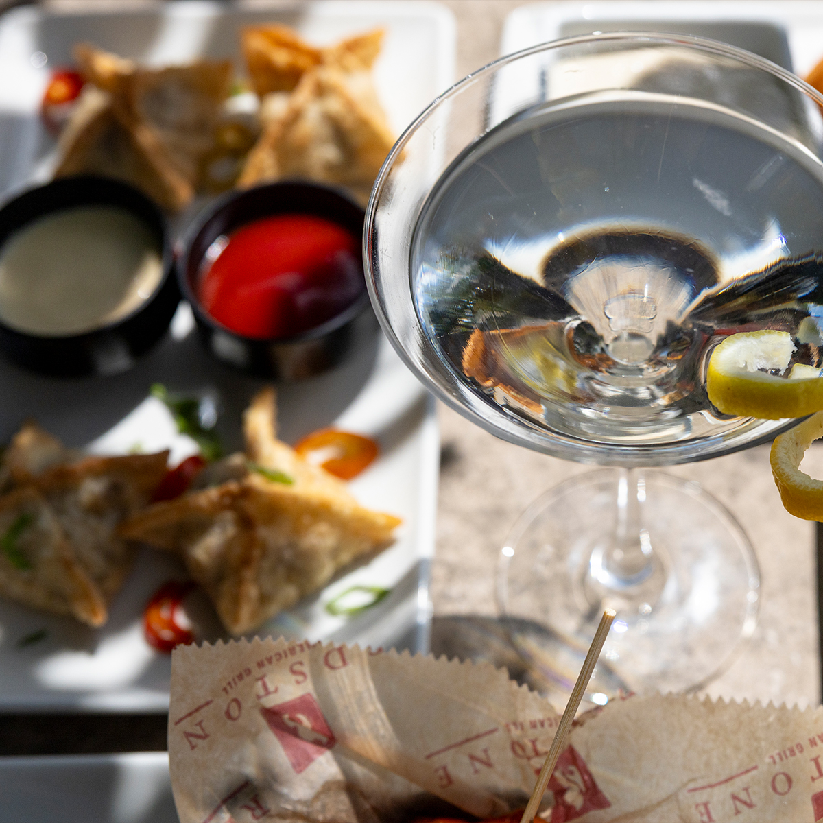 Happy Hour | pictured is a Vesper Martini & Cheesesteak Wontons