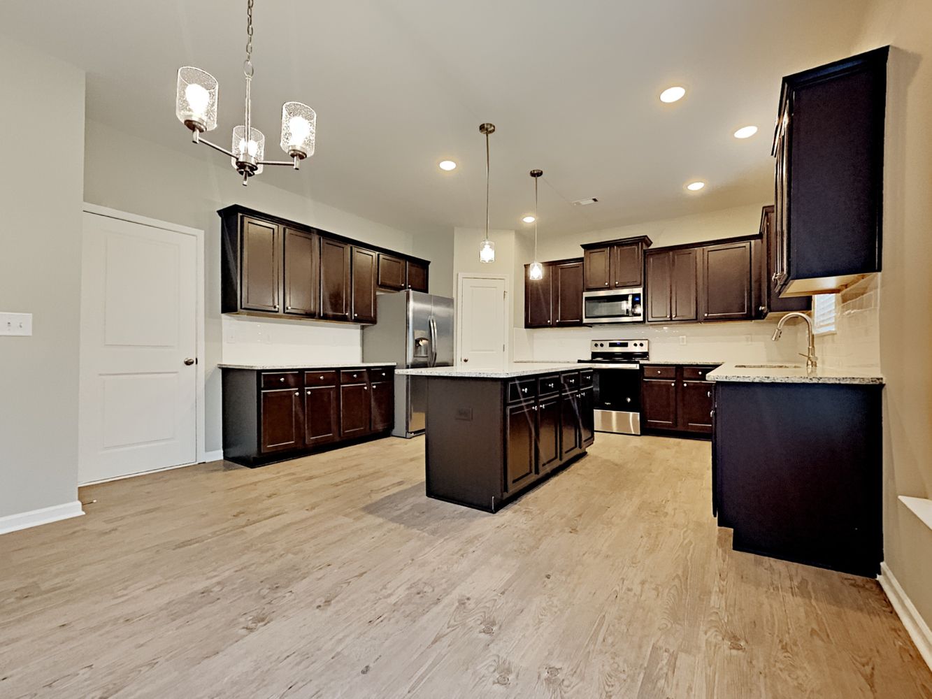 Stunning kitchen with island, stainless steel appliances, and recessed lighting at Invitation Homes Atlanta.