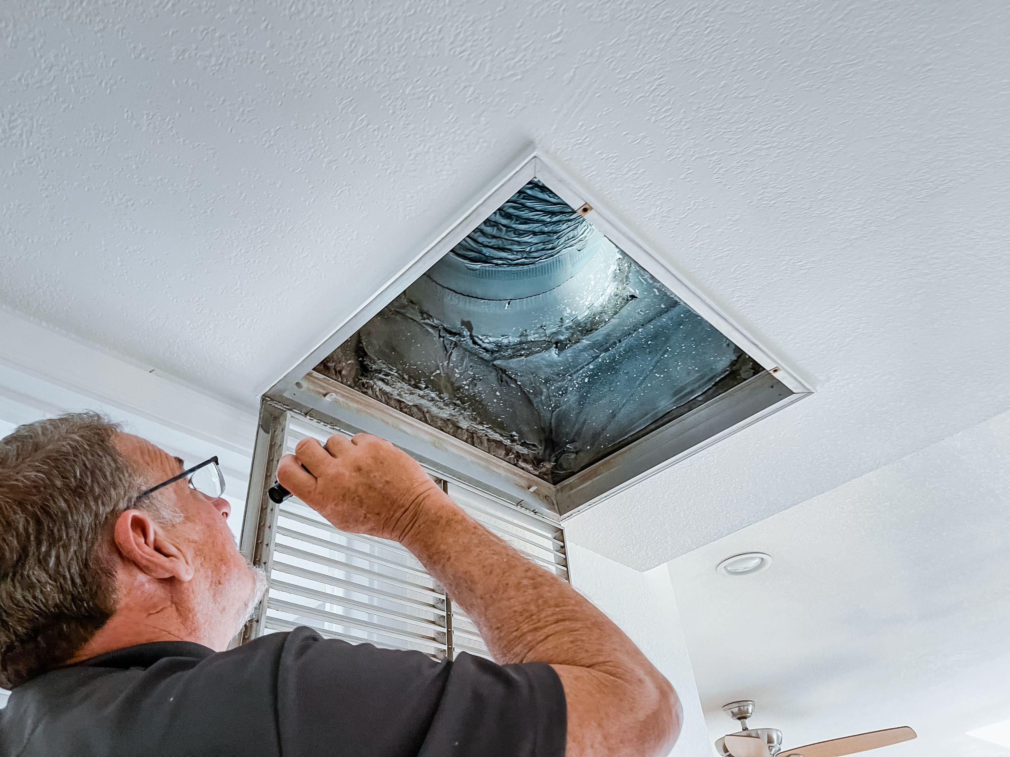 Home Inspector Jeff Hunter inspects the air ducts of the HVAC system.