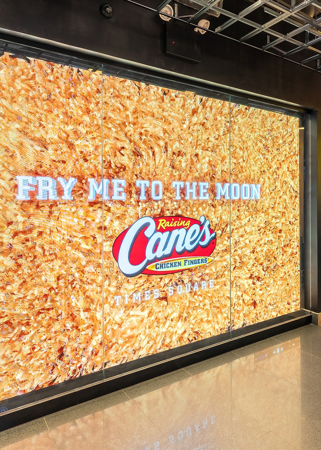 Raising Cane's wall that says "Fry Me To The Moon"