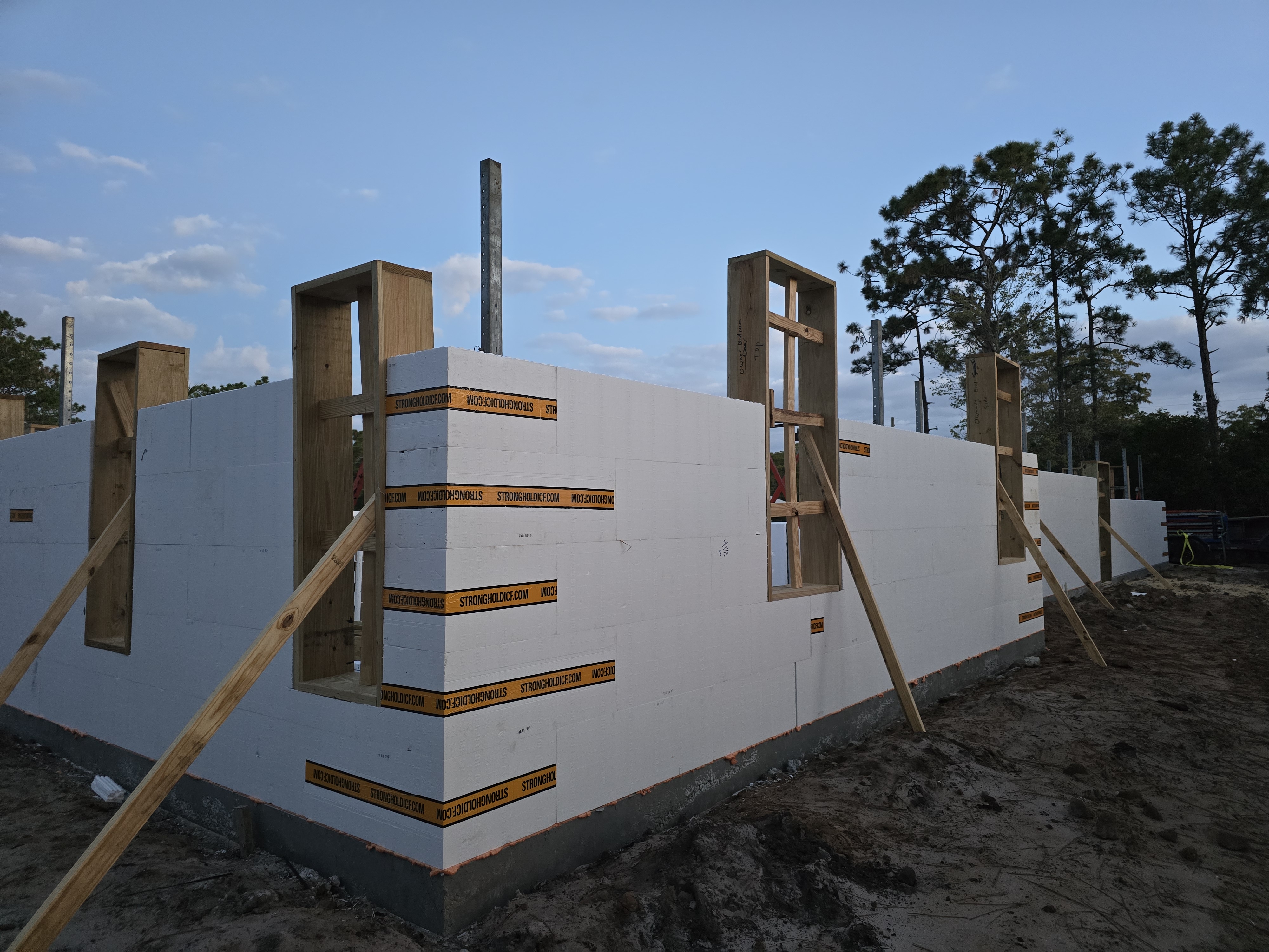 A construction site with the insulated concrete forms (ICFs) of a house foundation being built. The  