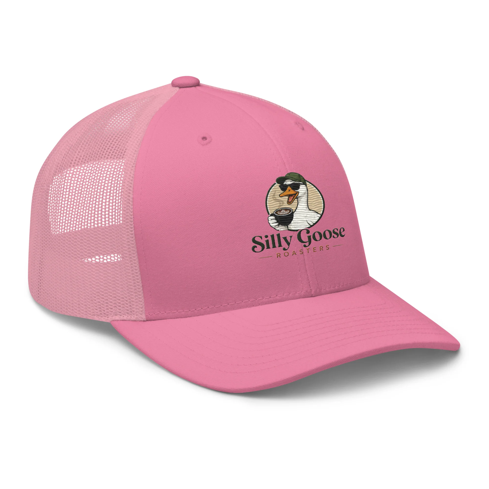 A pink trucker hat with a mesh back is shown against a white background. The front of the hat features a circular logo with a cartoon goose wearing sunglasses and a green hat, holding a cup of coffee. Below the logo, the words "Silly Goose Roasters" are printed in a dark green font with a thin underline.