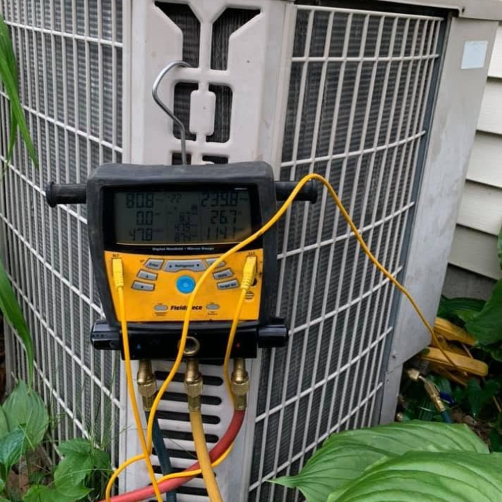 Digital manifold verifying refrigerant charge during an air conditioning service call.