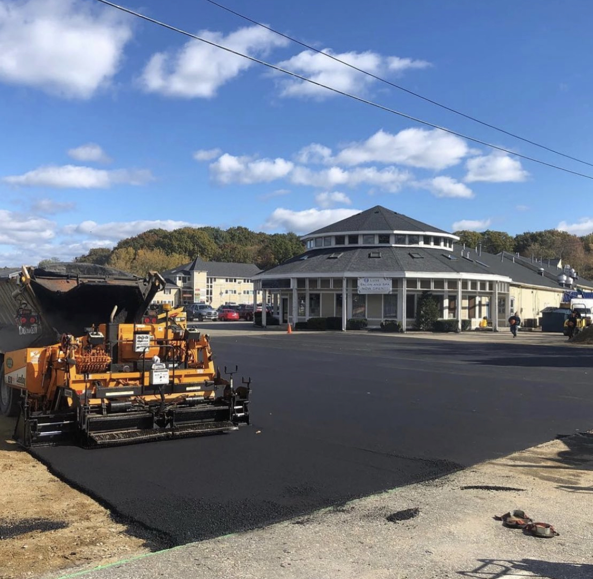 Professional commercial paving services with asphalt paver equipment for high-quality parking lot installation.