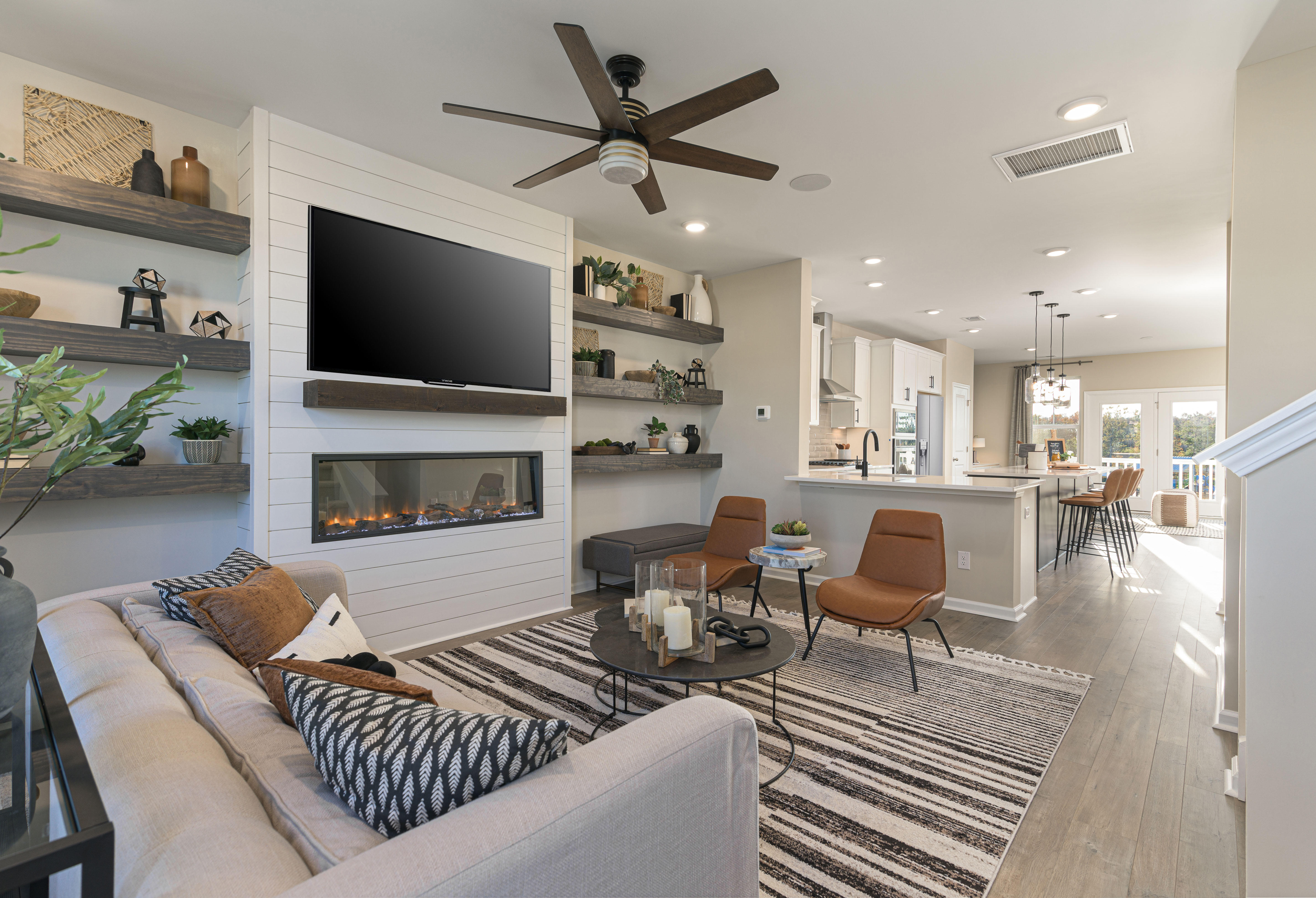 Open concept family room with television above a fireplace in the DRB Homes Recess Pointe community