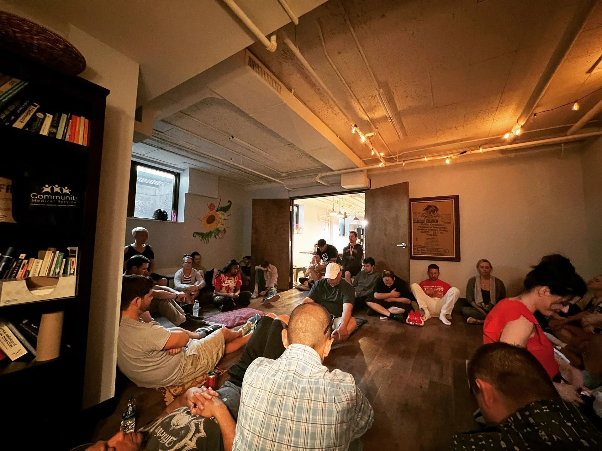 Group participants sit together during an indoor recovery meeting, fostering open conversation, peer encouragement, shared experiences, emotional support, and personal growth within a safe, welcoming community environment promoting lasting sobriety.