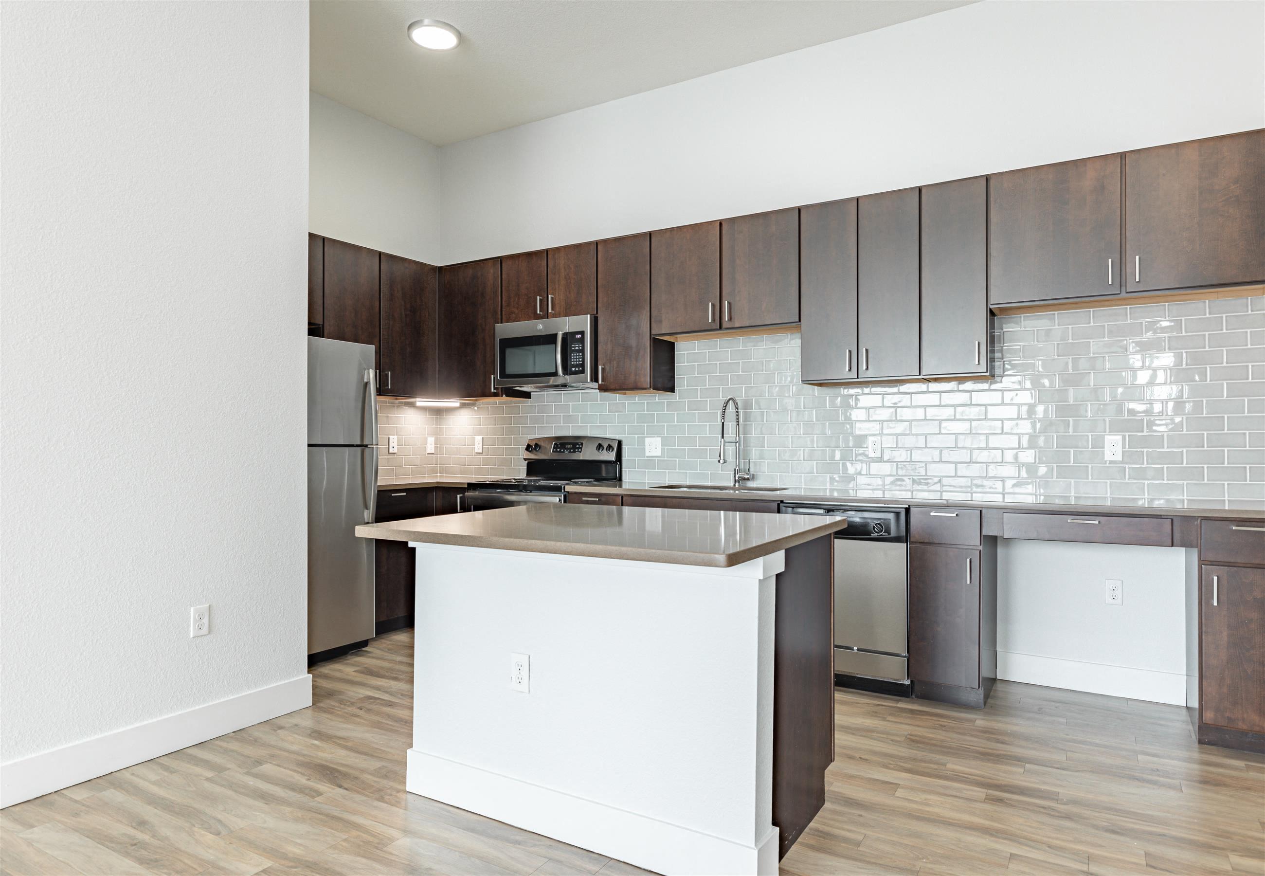 a kitchen with an island and stainless steel appliances
