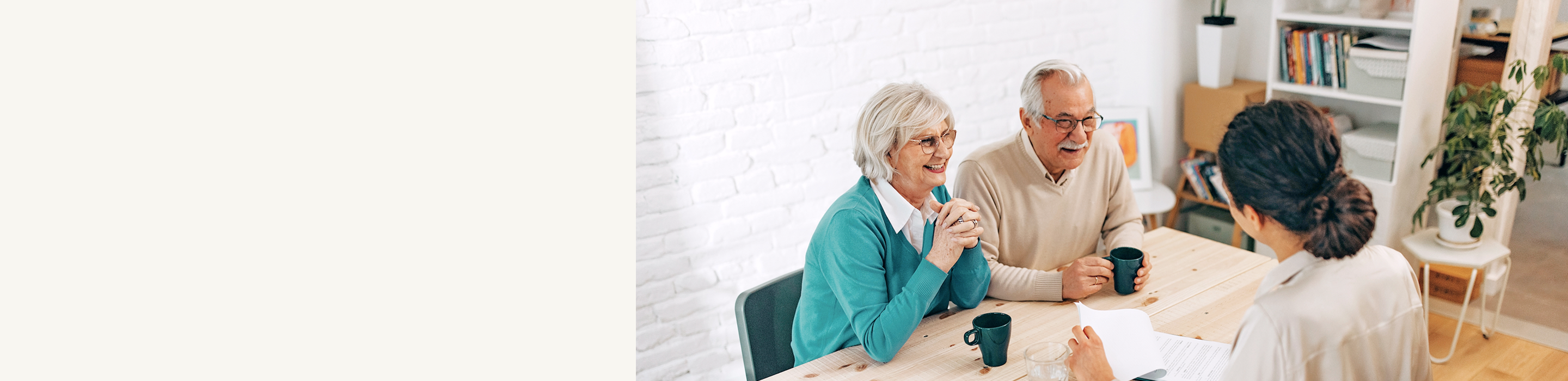 Senior clients speaking with an advisor across a table.