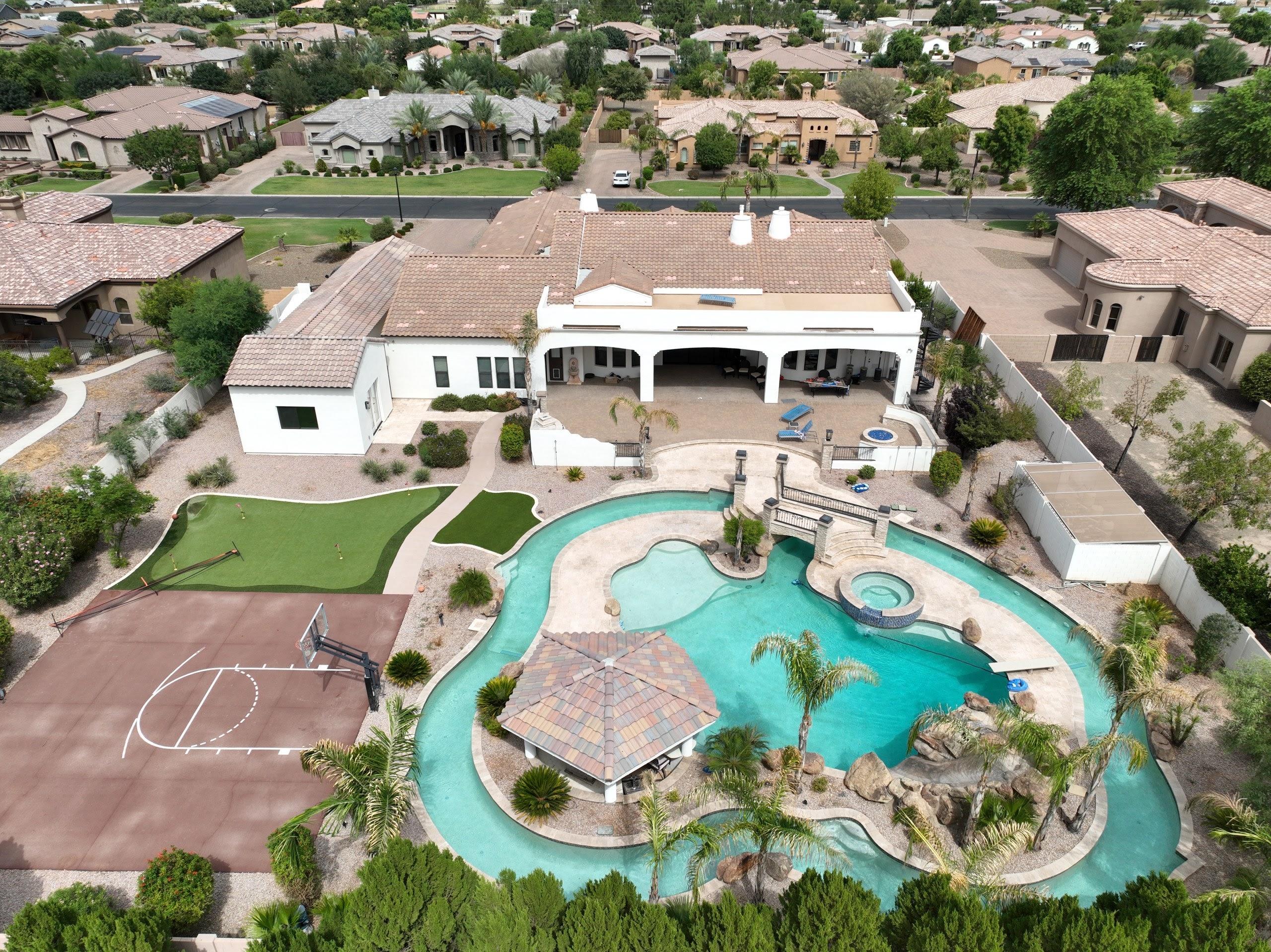 Overhead aerial of an Arizona home's backyard pool, patio and sport court, shot by Jack & Bean. 