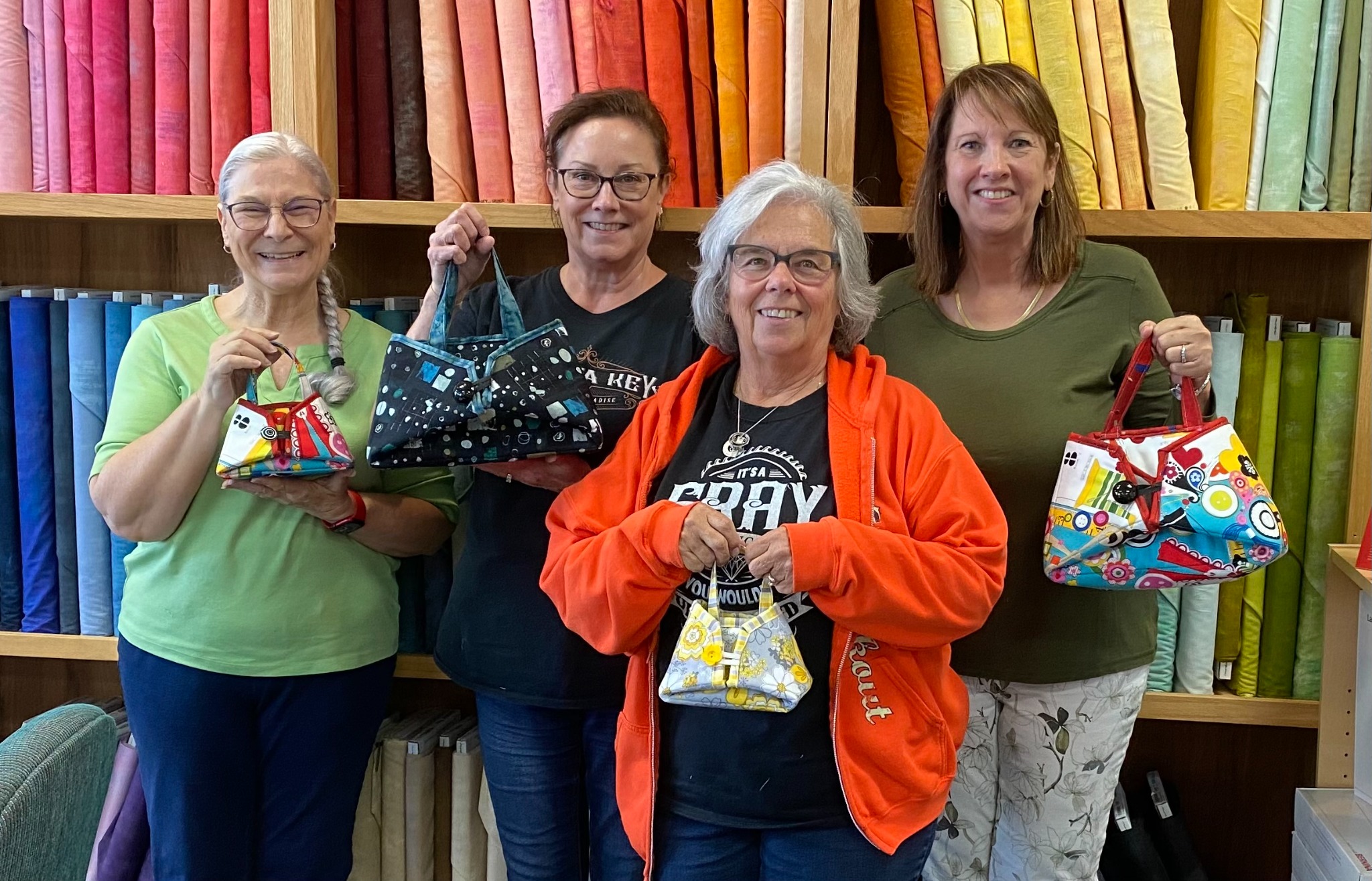 Students proudly display their handmade fabric purses after a Decorative Stitch class. This creative sewing workshop focused on decorative stitching, construction techniques, and finishing beautiful handmade accessories.