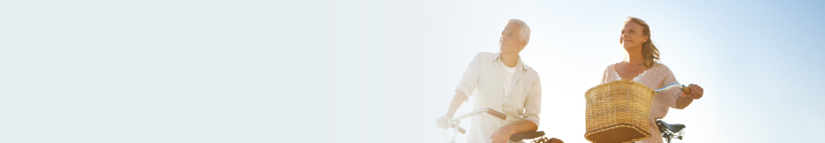 A couple riding their bikes together in the sun.