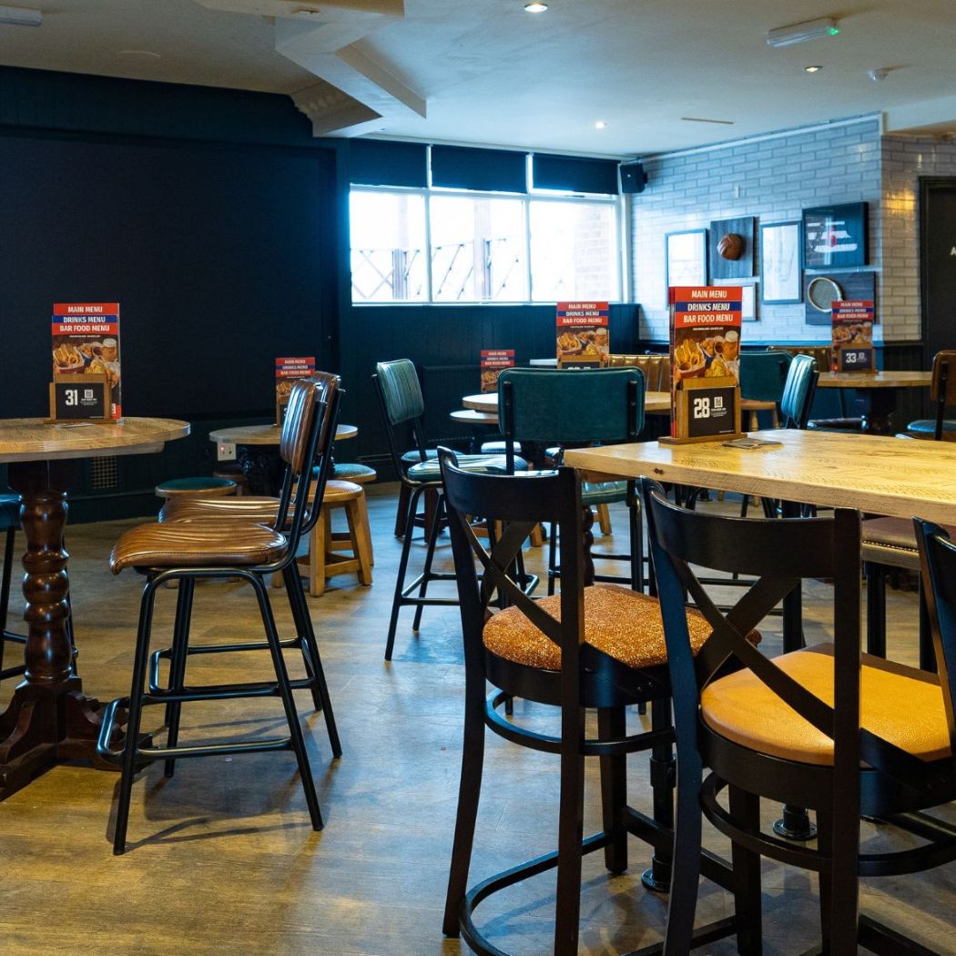 Versatile seating area with a mix of table styles, suited for both dining and drinks in a relaxed setting.
