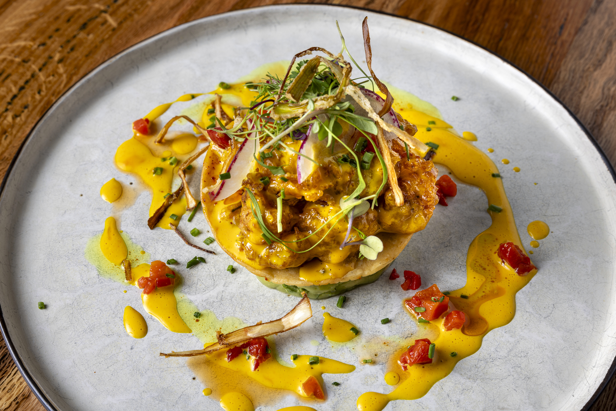 Crispy shrimp chicharr&oacute;n tostada topped with fresh ingredients, bright flavors, and a perfect crunch in every bite