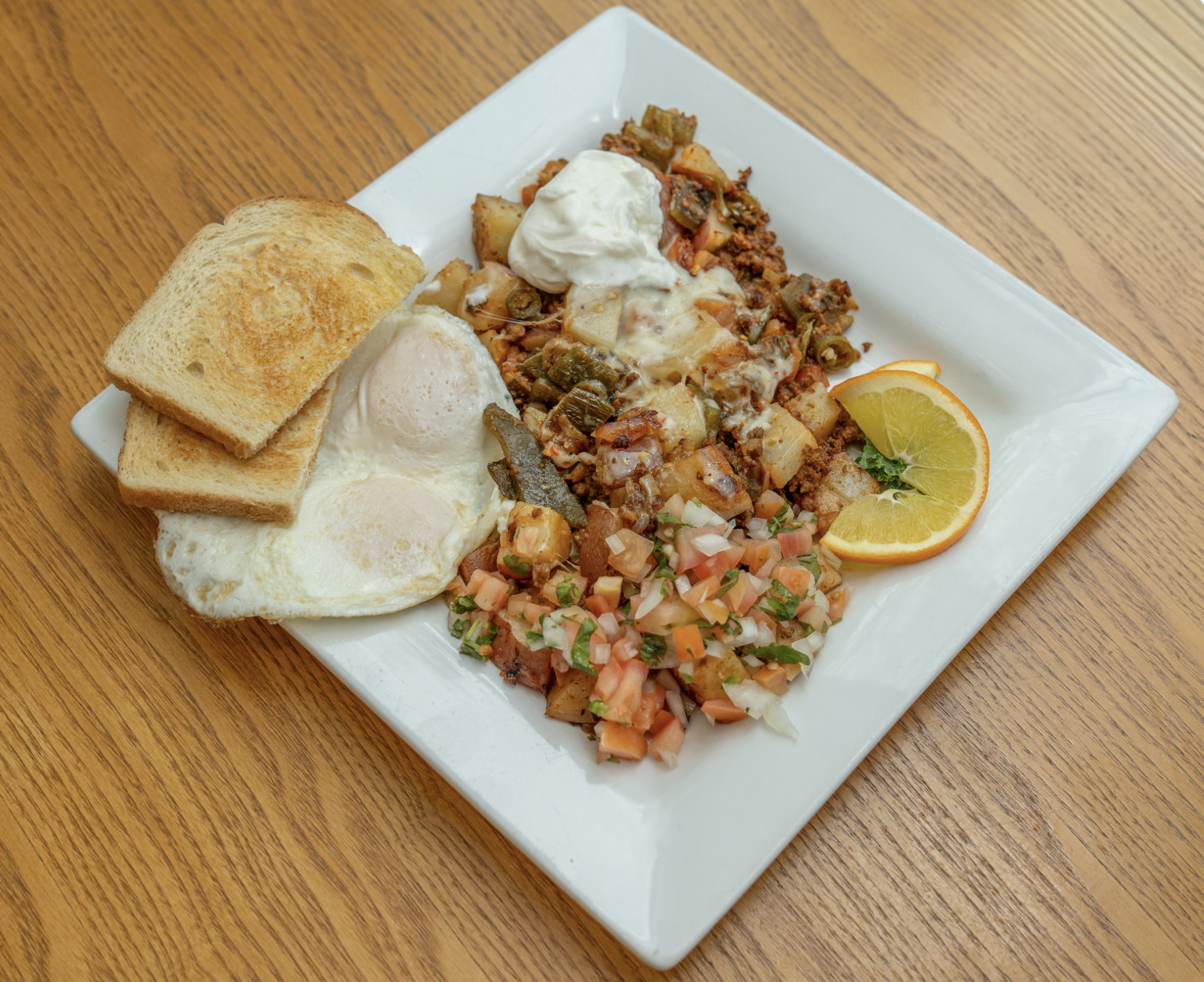 Two eggs and style, grilled red potatoes, your choice of meat, roasted poblano peppers, serrano peppers, tomatoes, onion & pepper, and jack cheese. Topped with sour cream and pico de gallo. Choice of toast.