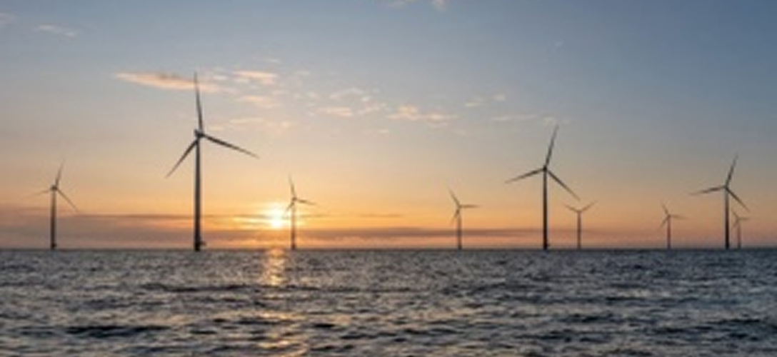 Éoliennes en mer au coucher du soleil.