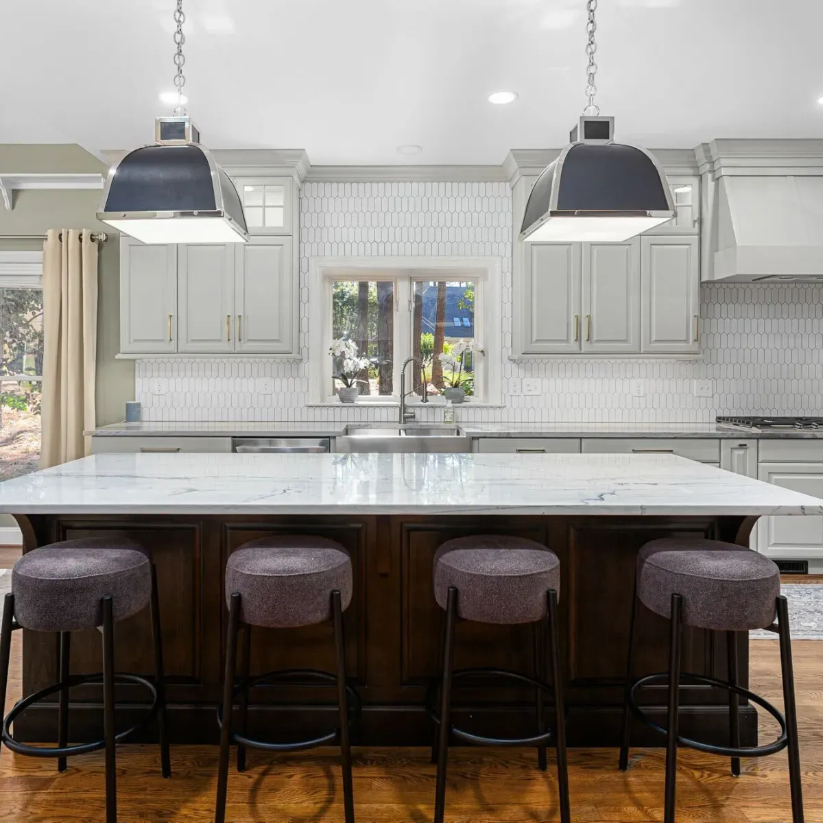 Luxury kitchen remodel in Central North Carolina featuring custom cabinetry, a large quartz island, and modern pendant lighting. This custom kitchen renovation highlights expert craftsmanship by a professional residential contractor serving the Badin Lake area.