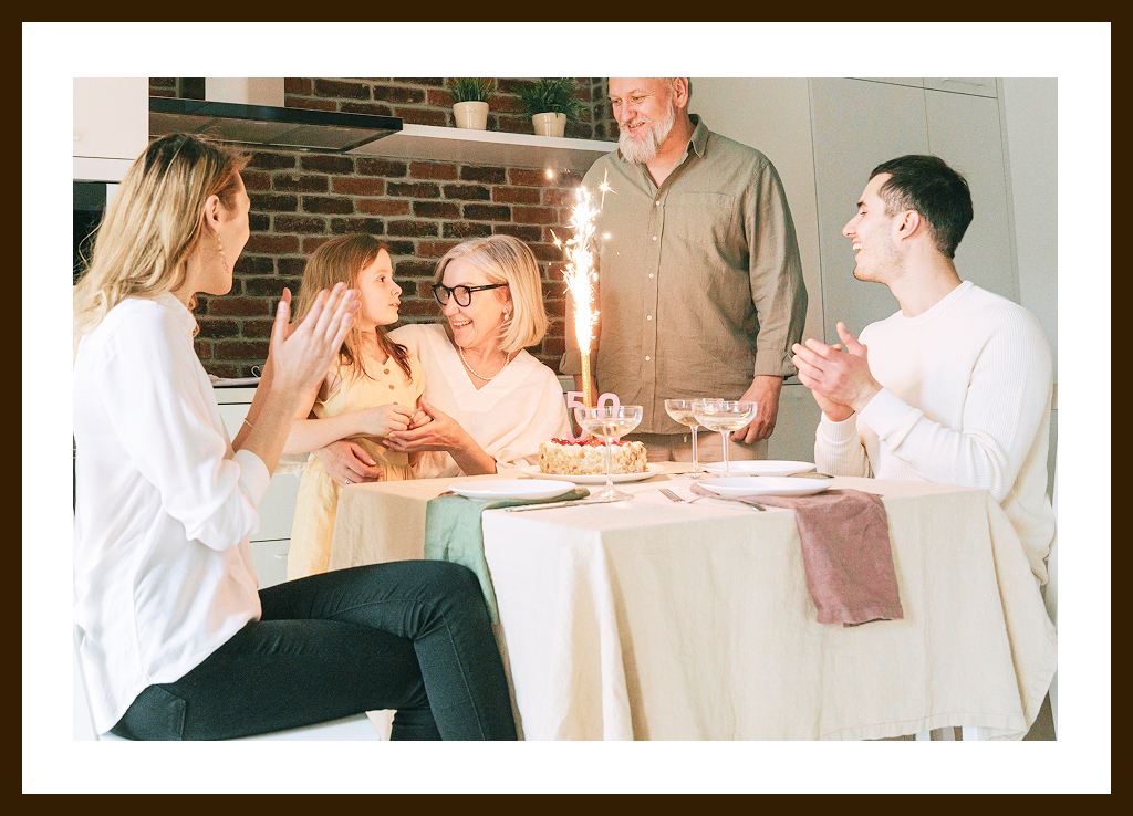 A grandmother celebrating her birthday with her husband, kids, and granddaughter.