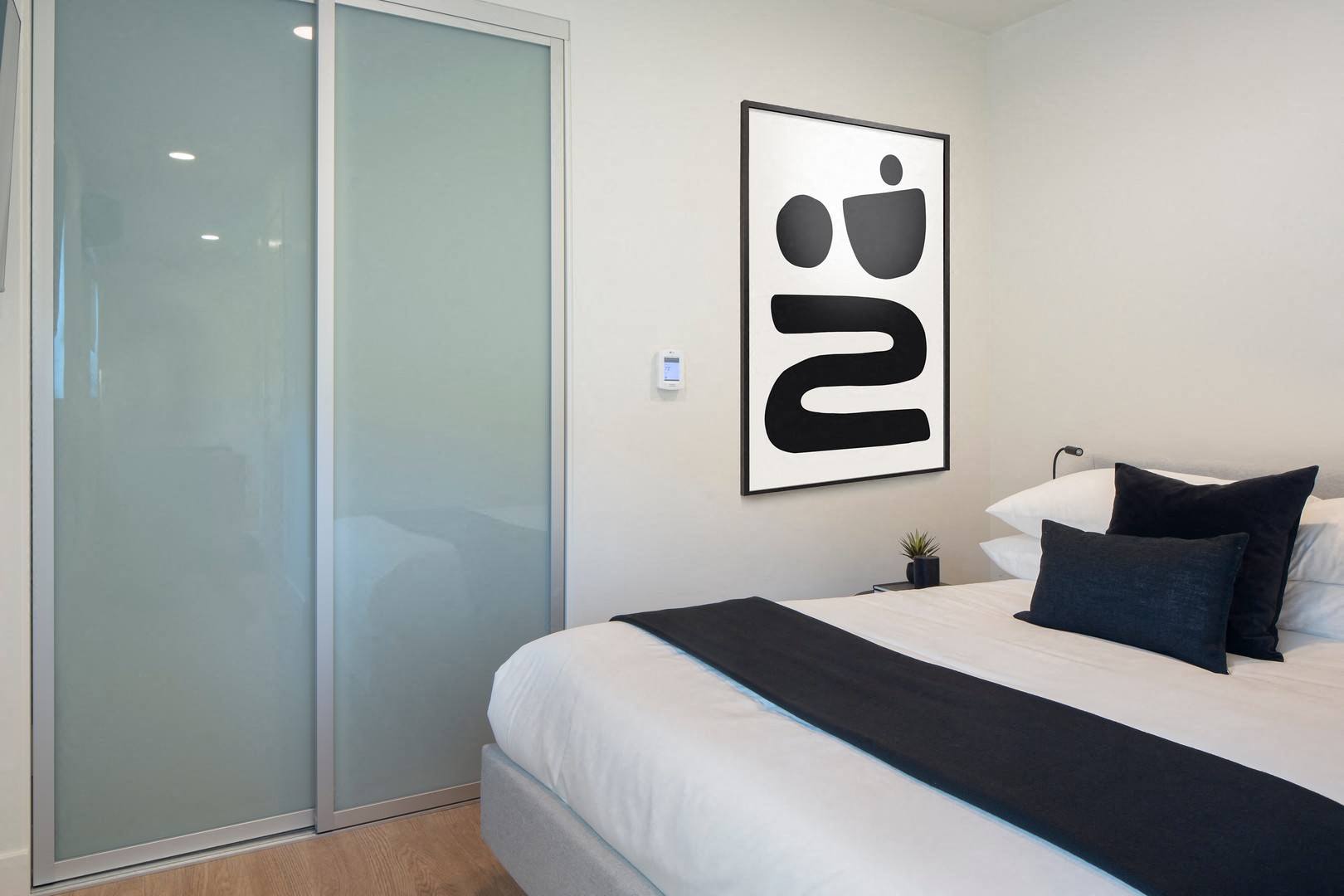a bedroom with a bed and a glass door