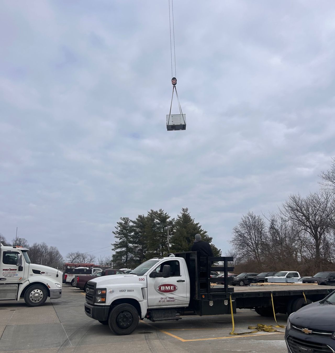 Crane lifting a commercial rooftop HVAC unit