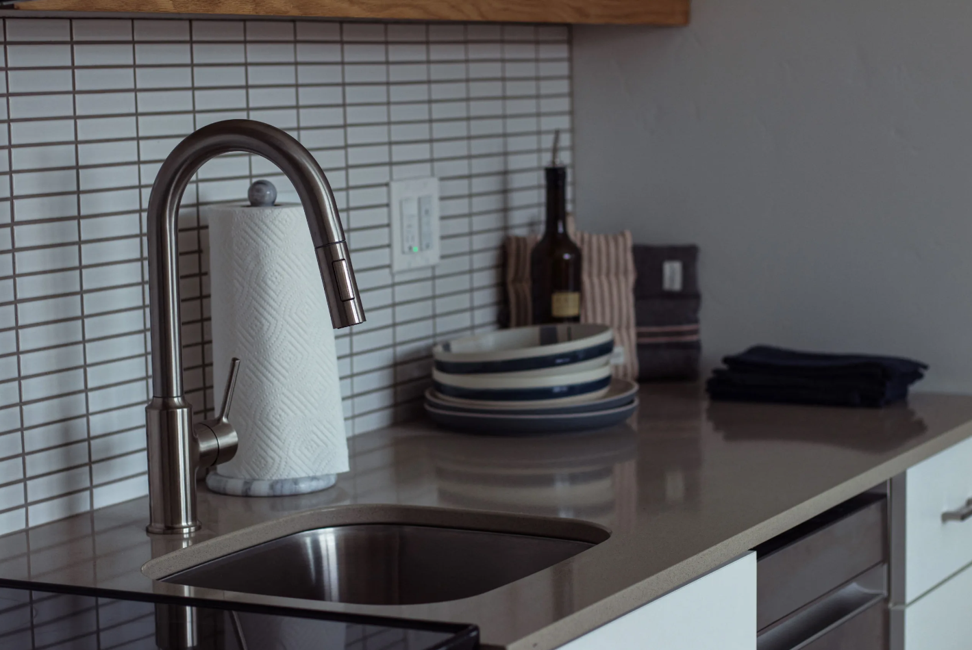 Elevated kitchen counter area with gooseneck  faucet and backsplash tiling