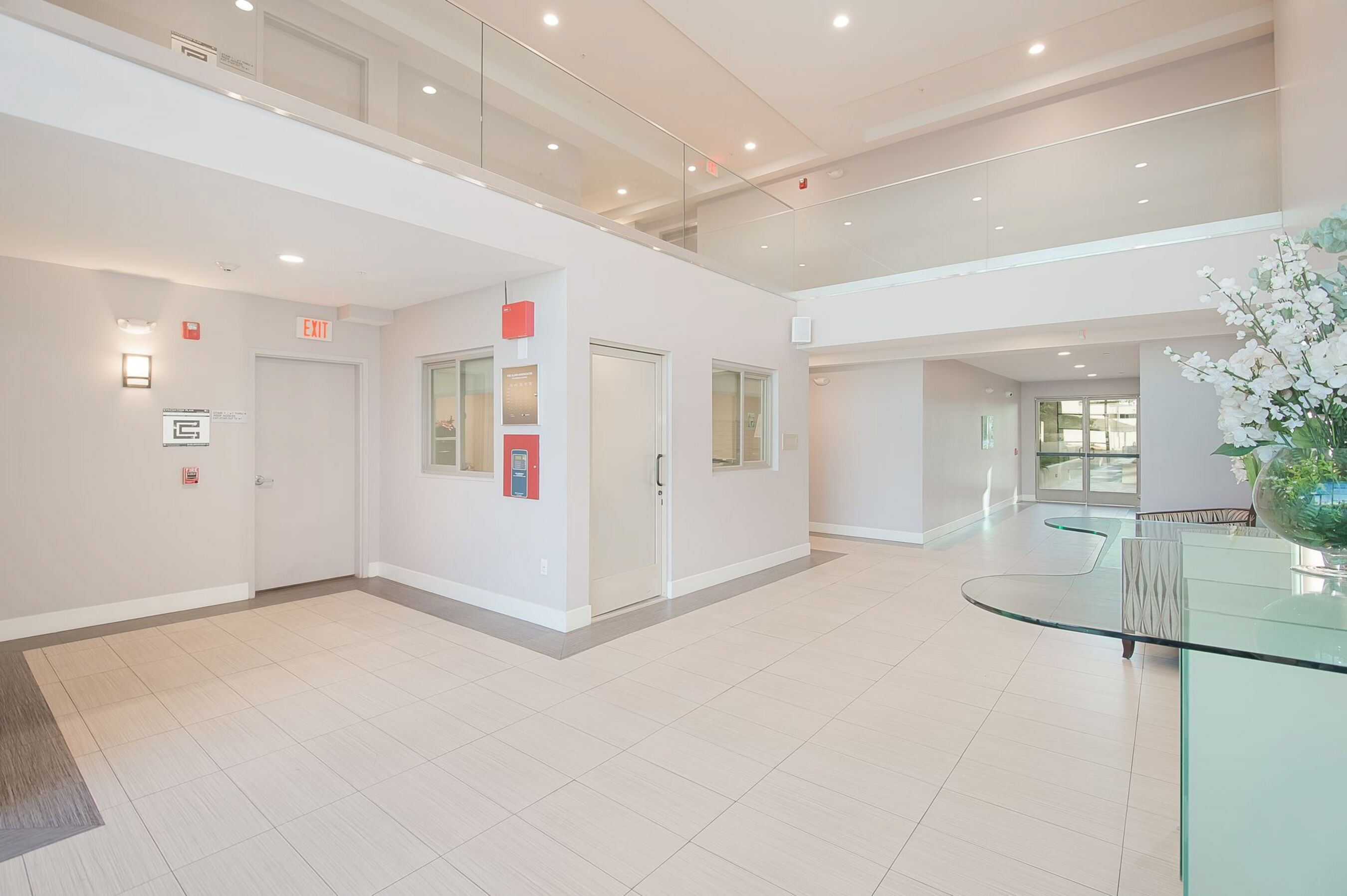 A white hallway with a glass table and chairs.