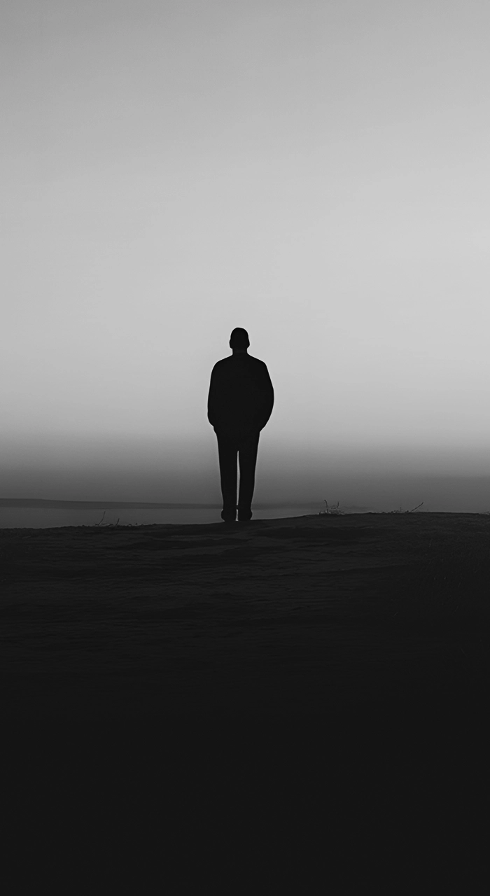 A black and white shot of an individual looking out over a vast expanse.